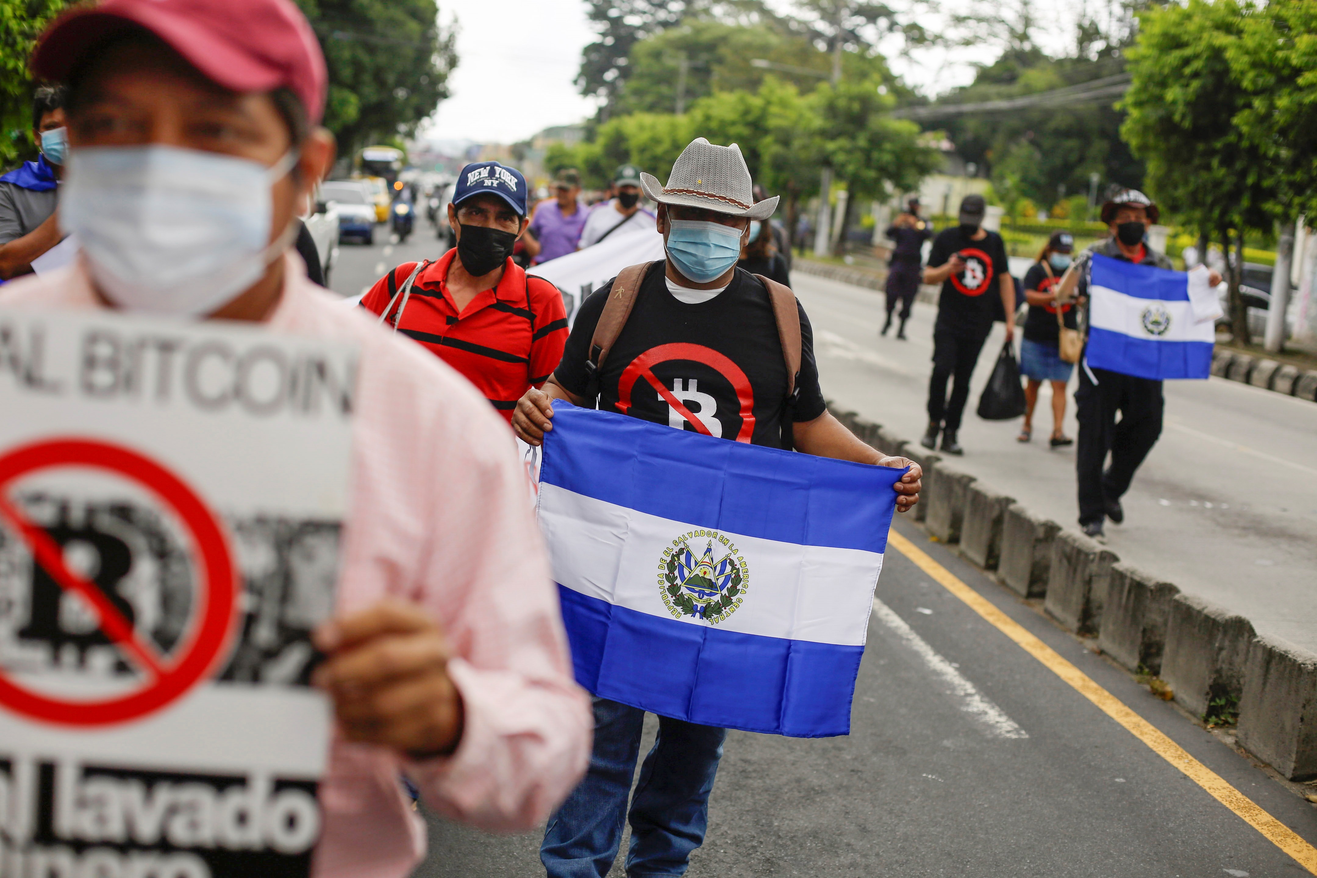 Personas sostienen banderas de El Salvador en una manifestación contra la denominada Ley Bitcóin, en San Salvador (El Salvador). EFE/Rodrigo Sura
