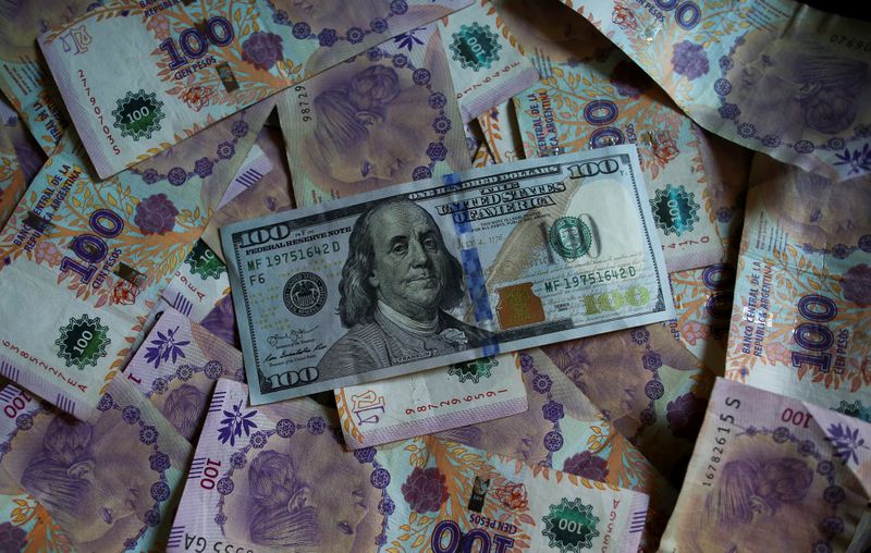 Foto de archivo - Un billete de cien dólares estadounidenses reposa sobre billetes de cien pesos de Argentina. Sep 3, 2019. REUTERS/Agustin Marcarian/Illustration