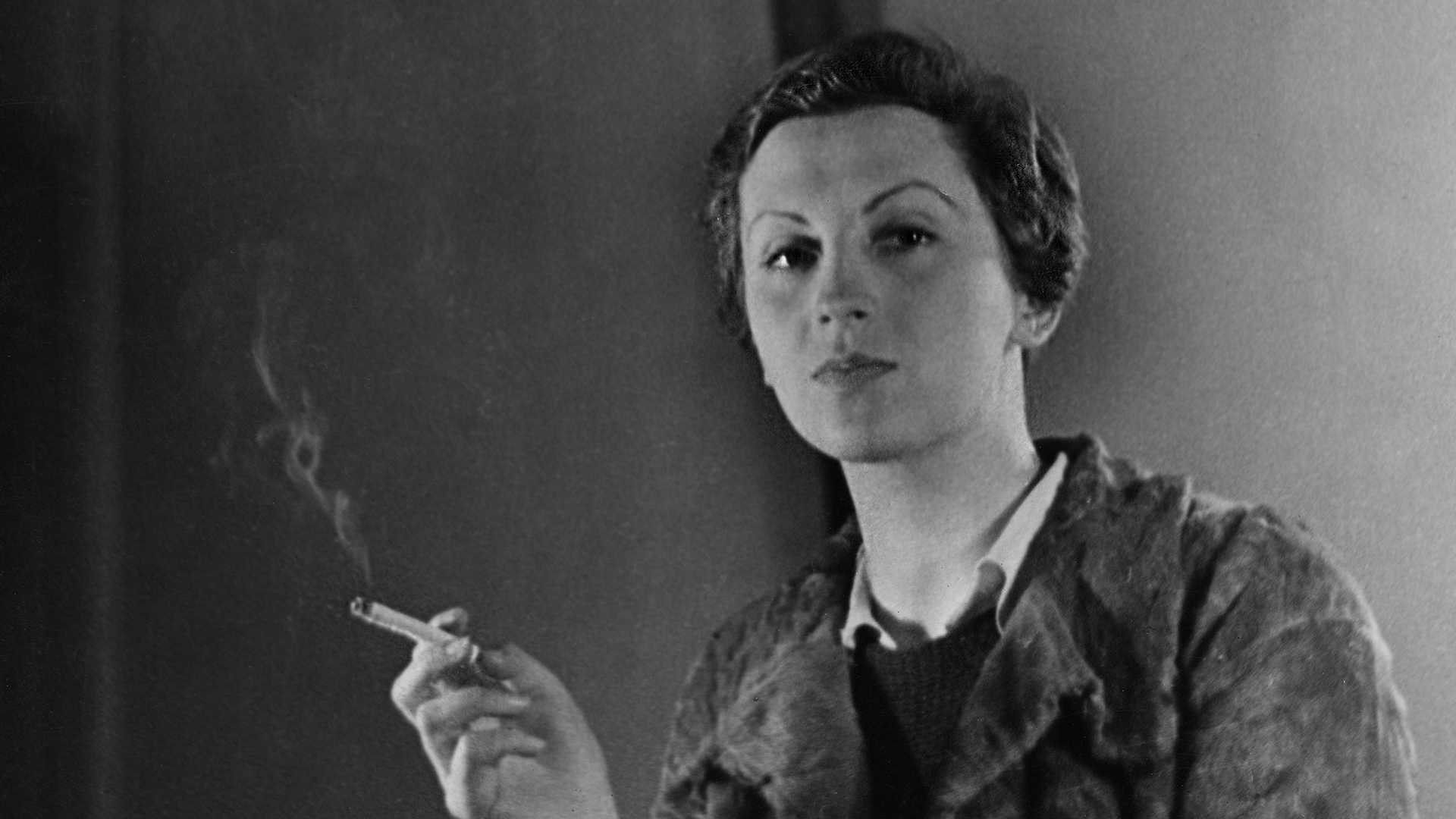 Portrait of German photographer Gerda Taro (born Gerta Pohorylle, 1910 - 1937) as she smokes a cigarette, seated behind a typewriter on a desk, Paris, France, 1936. (Photo by Fred Stein Archive/Getty Images)