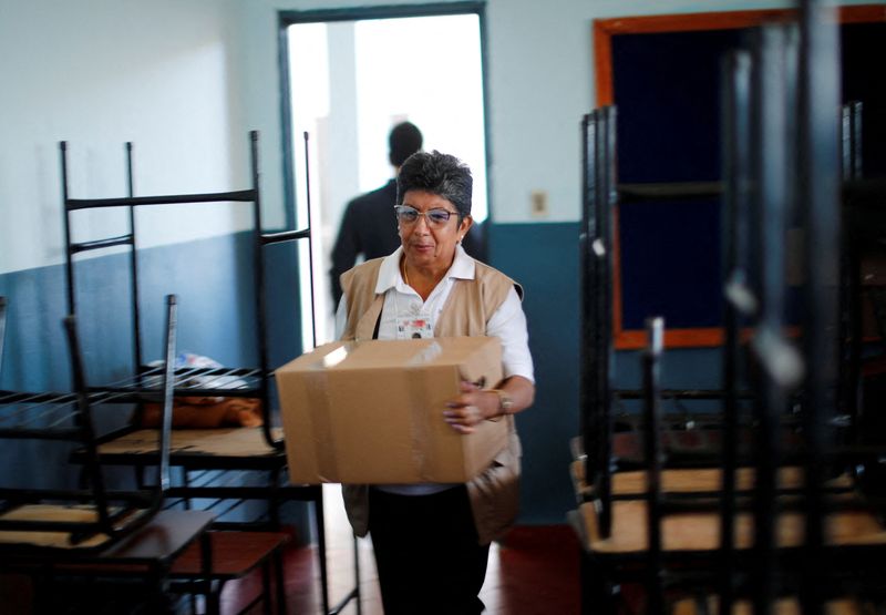 Una funcionaria del Tribunal Superior de Justicia Electoral de Paraguay mueve una caja que contiene una máquina de votación en una escuela pública (REUTERS/Agustin Marcarian)