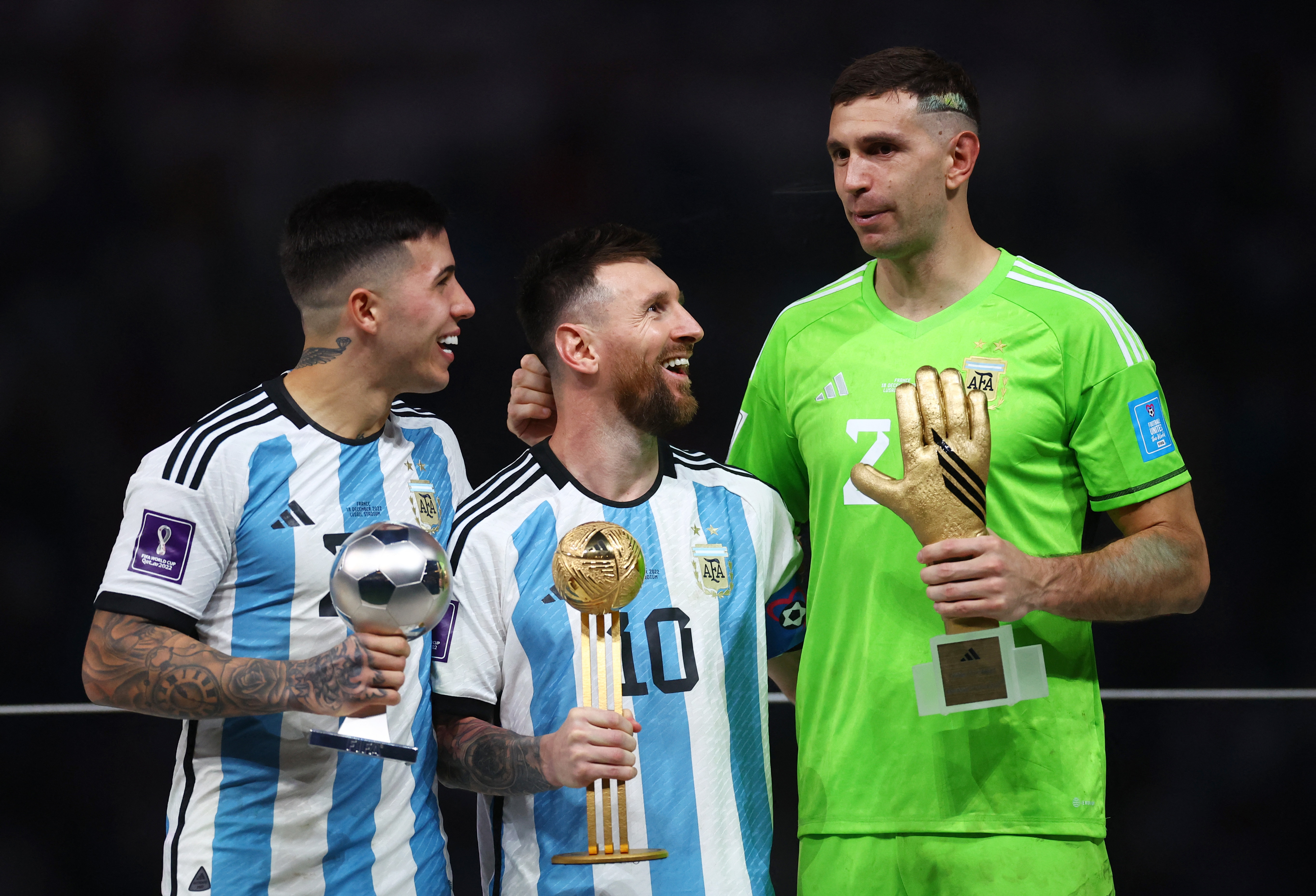 El look del Dibu Martínez, acá recibiendo el premio al mejor arquero, junto a Enzo Fernández y Lionel Messi (REUTERS/Kai Pfaffenbach)