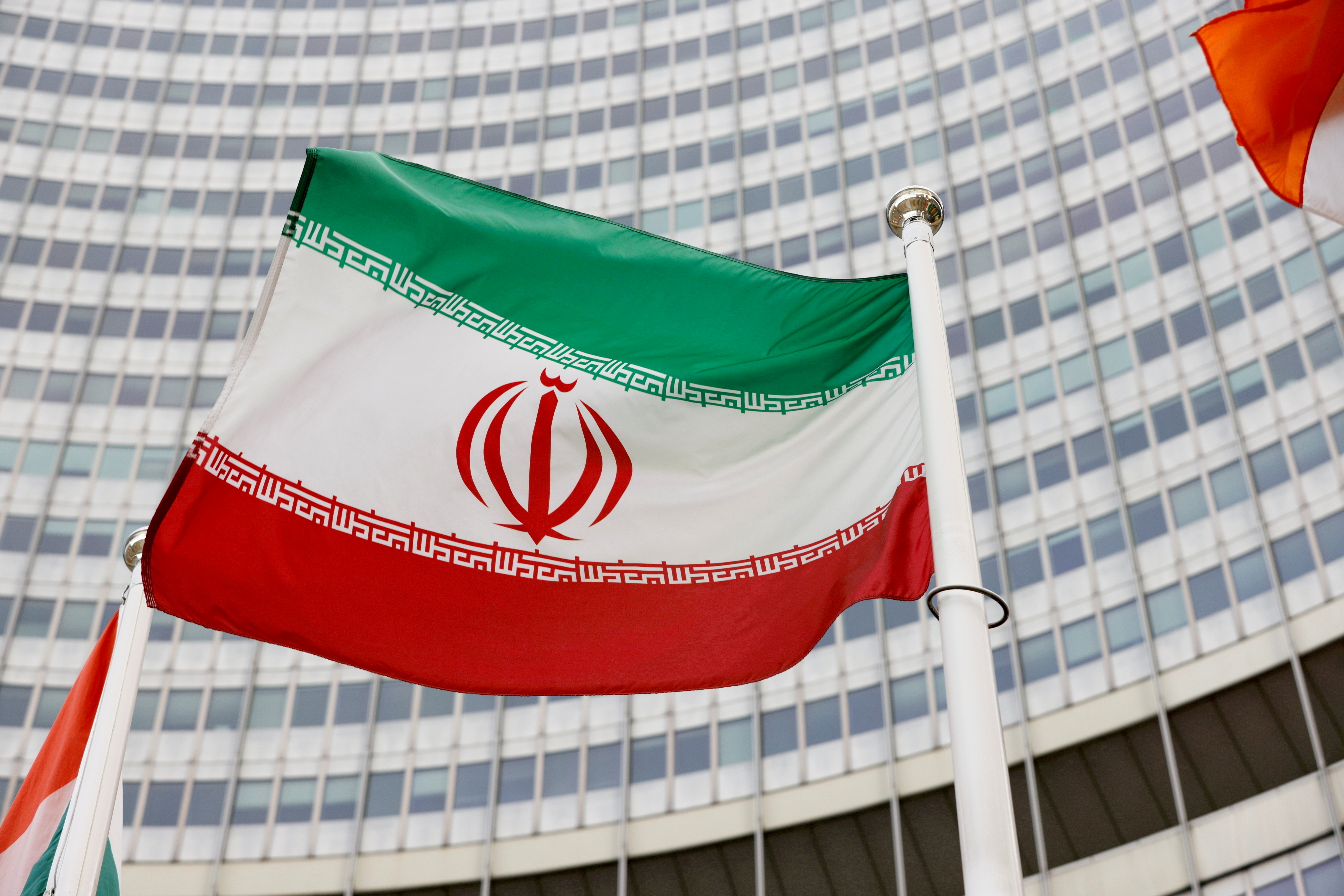 La bandera iraní ondea frente a la sede del Organismo Internacional de Energía Atómica (OIEA) en Viena, Austria, el 23 de mayo de 2021. (REUTERS)
