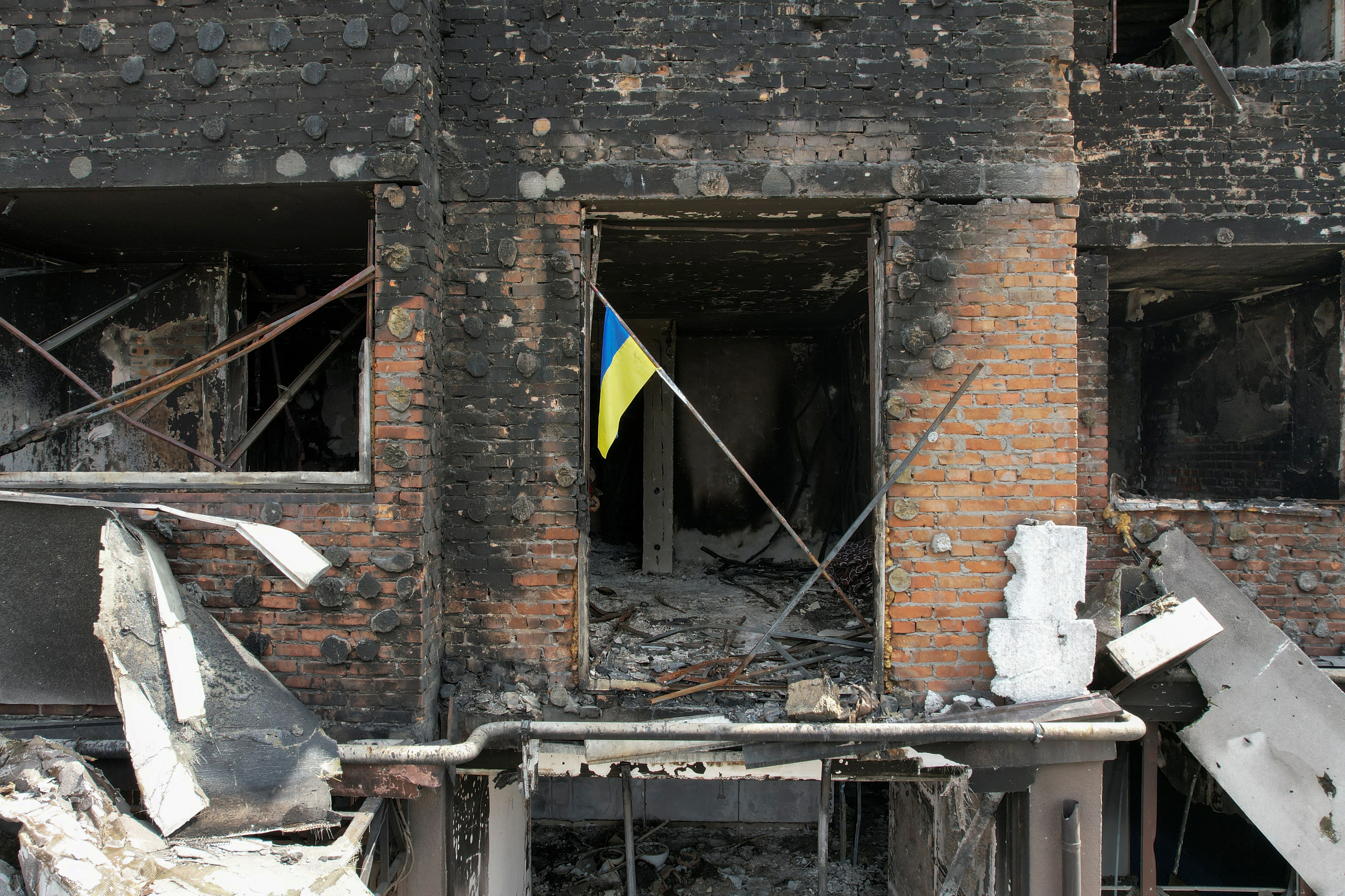 Una bandera nacional ucraniana se ve en un apartamento de un edificio residencial dañado durante la invasión rusa de Ucrania en la ciudad de Irpin, en las afueras de Kiev, Ucrania 29 de abril de 2022. Imagen tomada con un dron. REUTERS/Valentyn Ogirenko