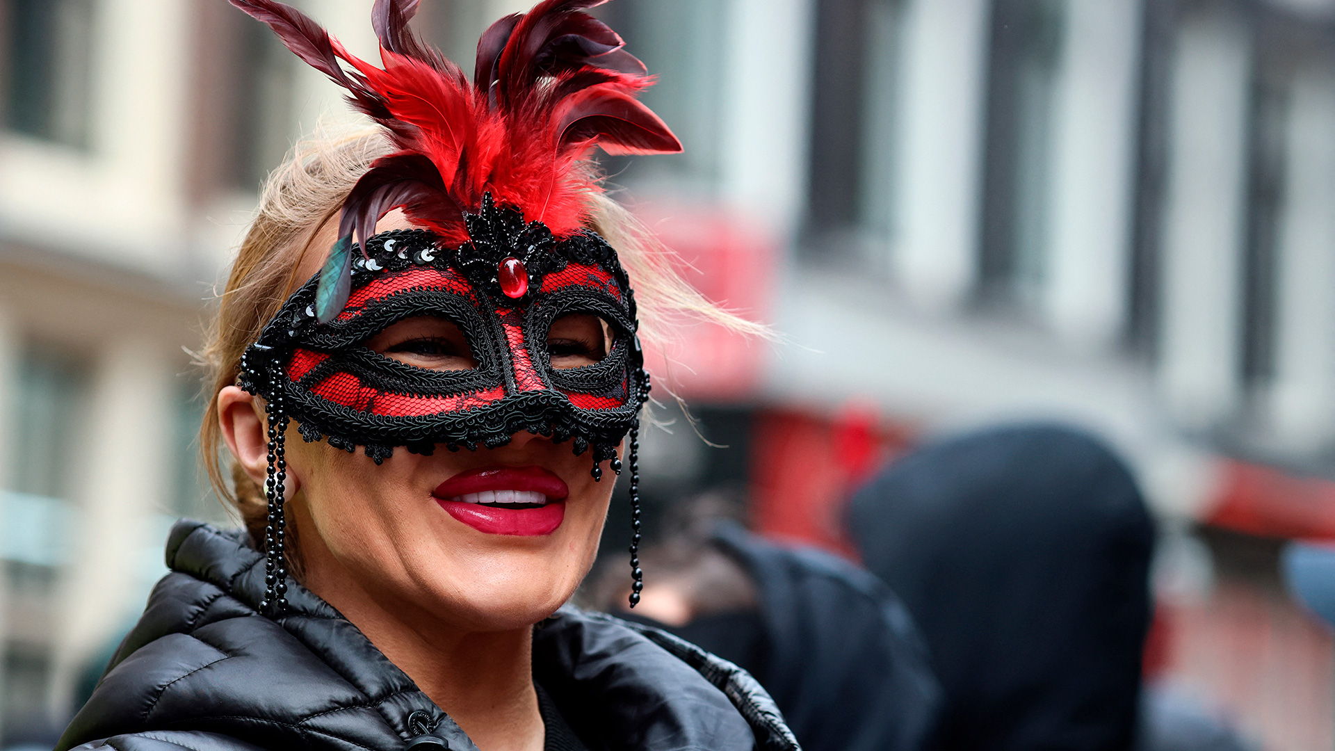 Una manifestante que cubrió su rostro para permanecer en el anonimato durante la protesta contra los planes de cerrar el histórico barrio rojo de Ámsterdam el 30 de marzo de 2023 (Kenzo TRIBOUILLARD / AFP)