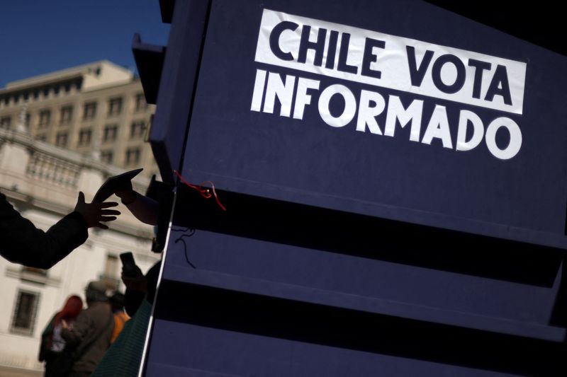 Una persona recibe una copia de la propuesta de nueva Constitución en Santiago (REUTERS/Ivan Alvarado)