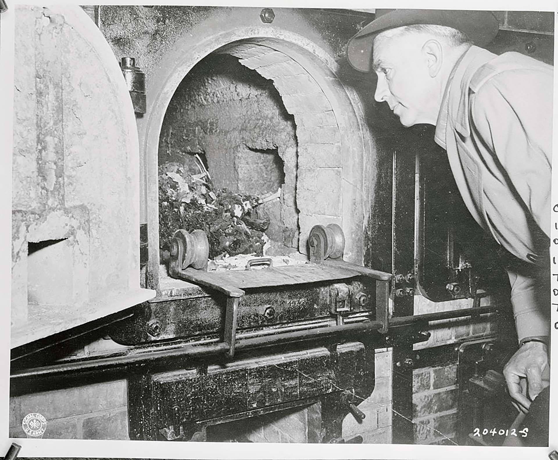 El representante Ed V. Izak, California, observa los cráneos y los cuerpos de los prisioneros en un incinerador en el infame campo de concentración de Buchenwald cerca de Weimar, Alemania. Izak era miembro de un grupo del Congreso que viajó para presenciar las atrocidades nazis (Bettmann Archive)
