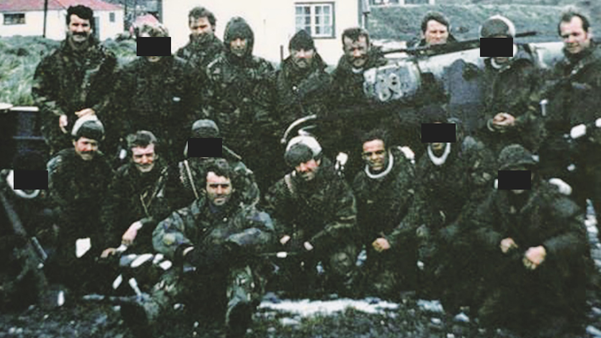 Miembros de la SAS después de la reconquista de las Islas Georgias el 24 de abril de 1982. Aston está sentado en el medio de la primera fila. En la foto hay nueve que no continuarían en Malvinas seis semanas después: seis por muertes y tres por heridas ("The War Zone")