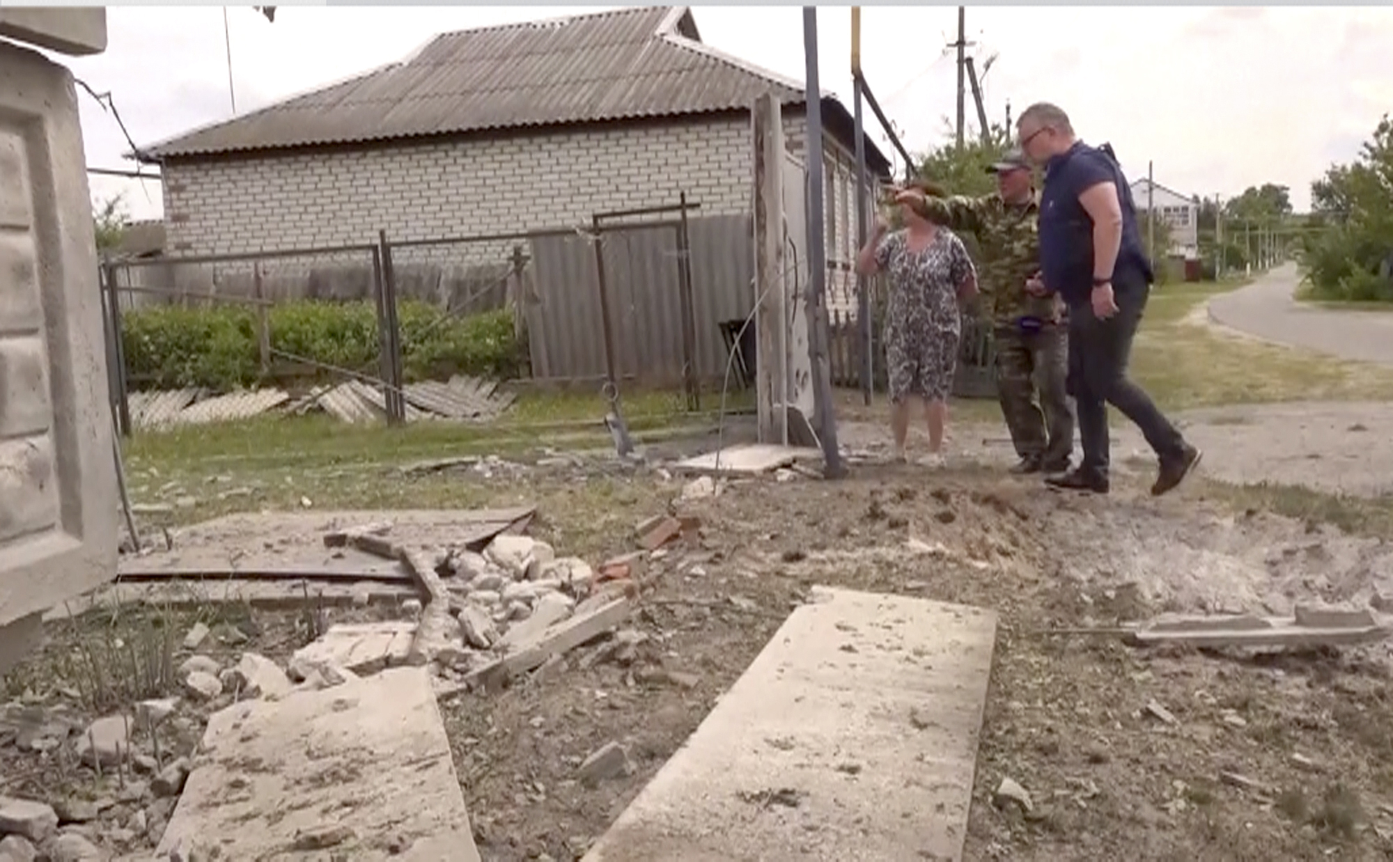 Personas señalando a un edificio dañado en la región de Belgorod, el lunes 22 de mayo (AP Foto)