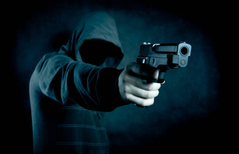 Imágen de referencia de hombre disparando con arma de fuego. Recuperado de: www.istockphoto.com