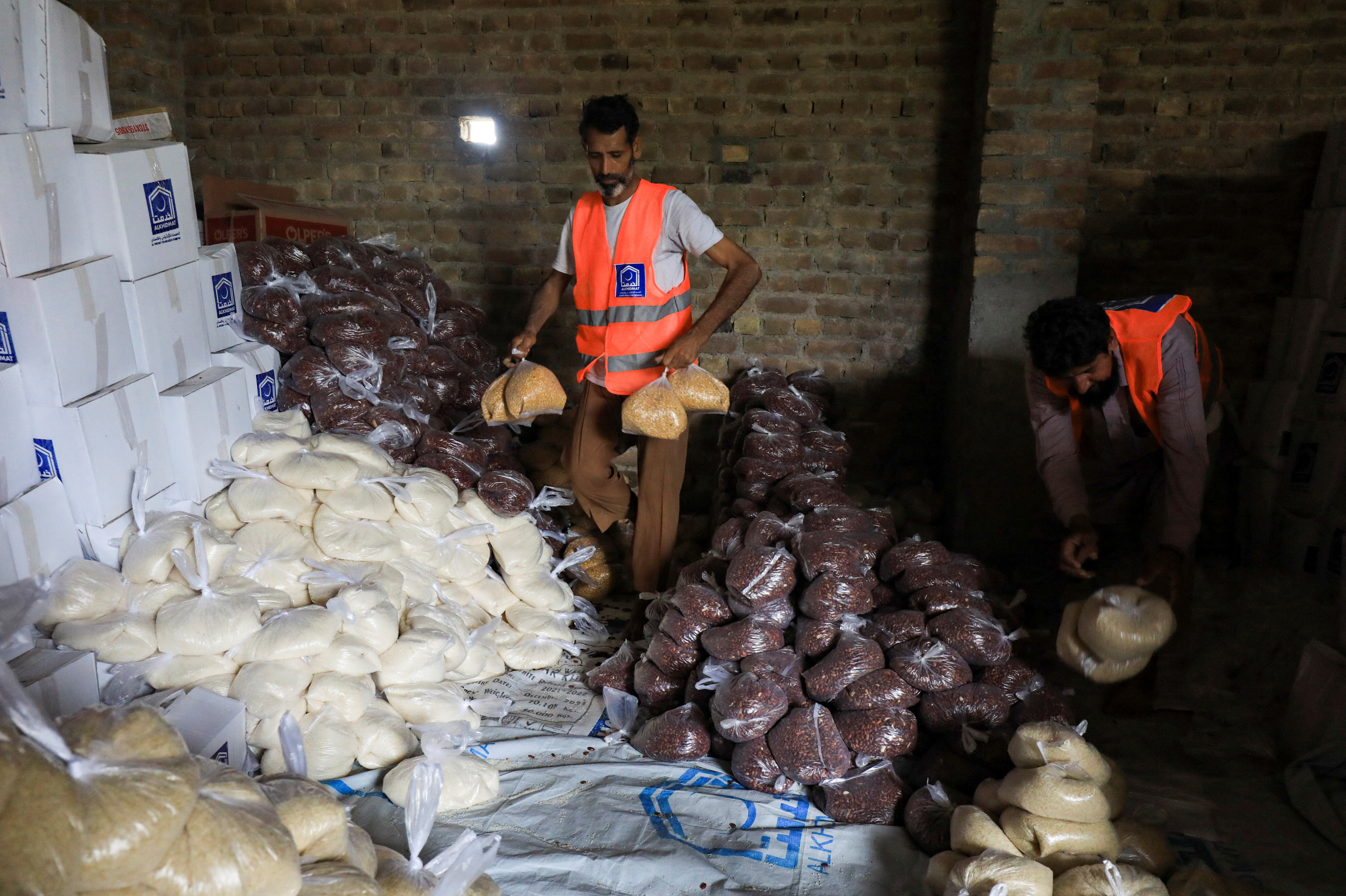 Voluntarios preparan paquetes de comida para los damnificados por las inundaciones (REUTERS/Fayaz Aziz)