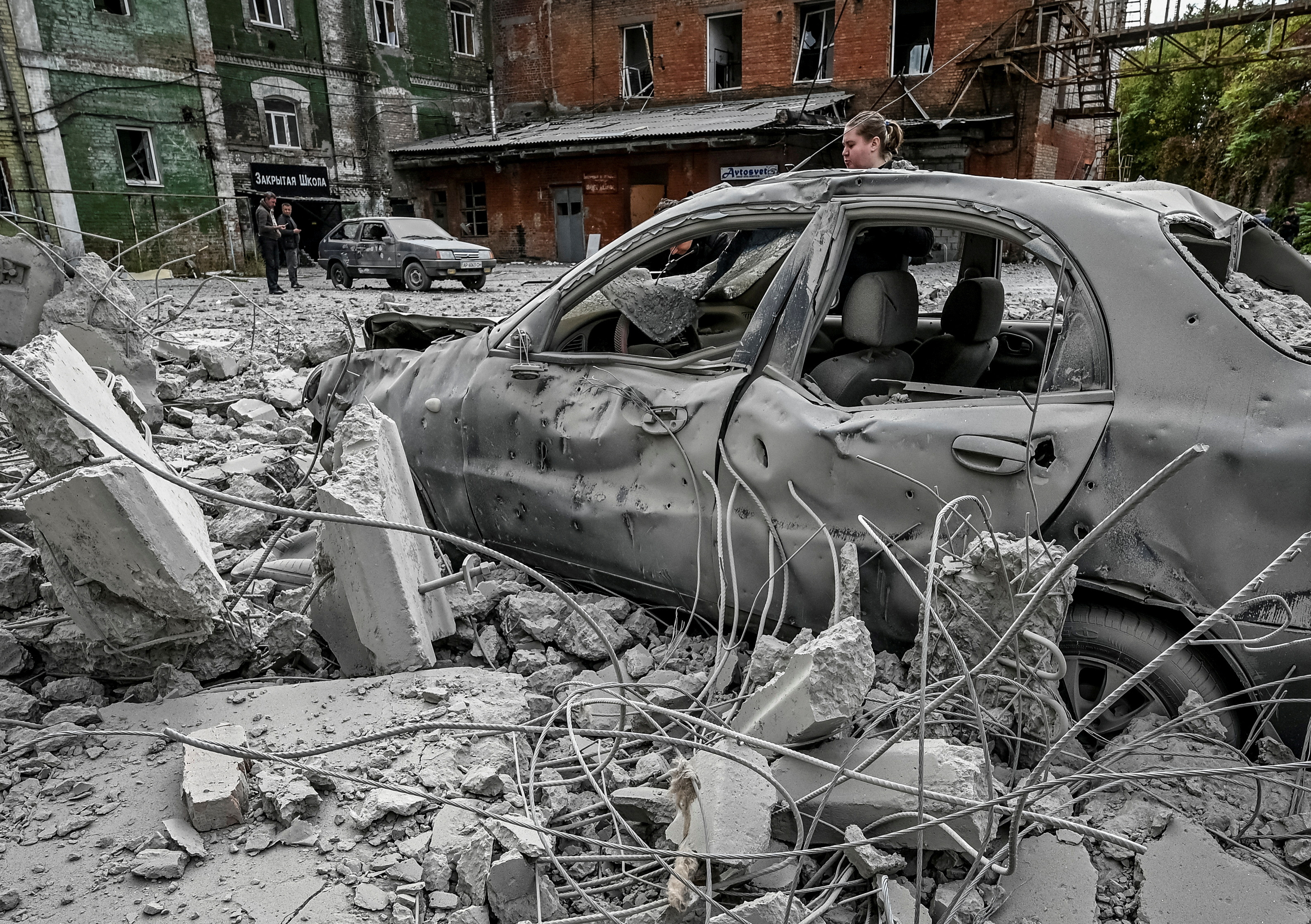 Una mujer junto a su coche destruido cerca de un viejo molino, construido alrededor de 1885, también destruido durante un ataque de misiles rusos en Zaporizhzhia, Ucrania 14 de octubre de 2022. REUTERS/Stringer/Archivo