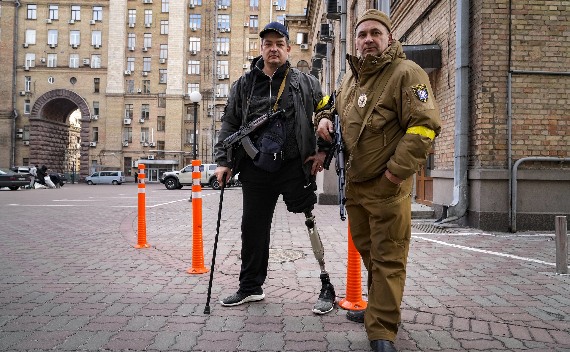 Dos voluntarios patrullando las calles desiertas de un barrio cercano al centro histórico. Uno de ellos perdió una pierna luchando contra los separatistas pro-rusos en 2014 en Luhansk. Forman parte de la resistencia popular organizada en las principales ciudades ucranianas. AP Photo/Efrem Lukatsky.