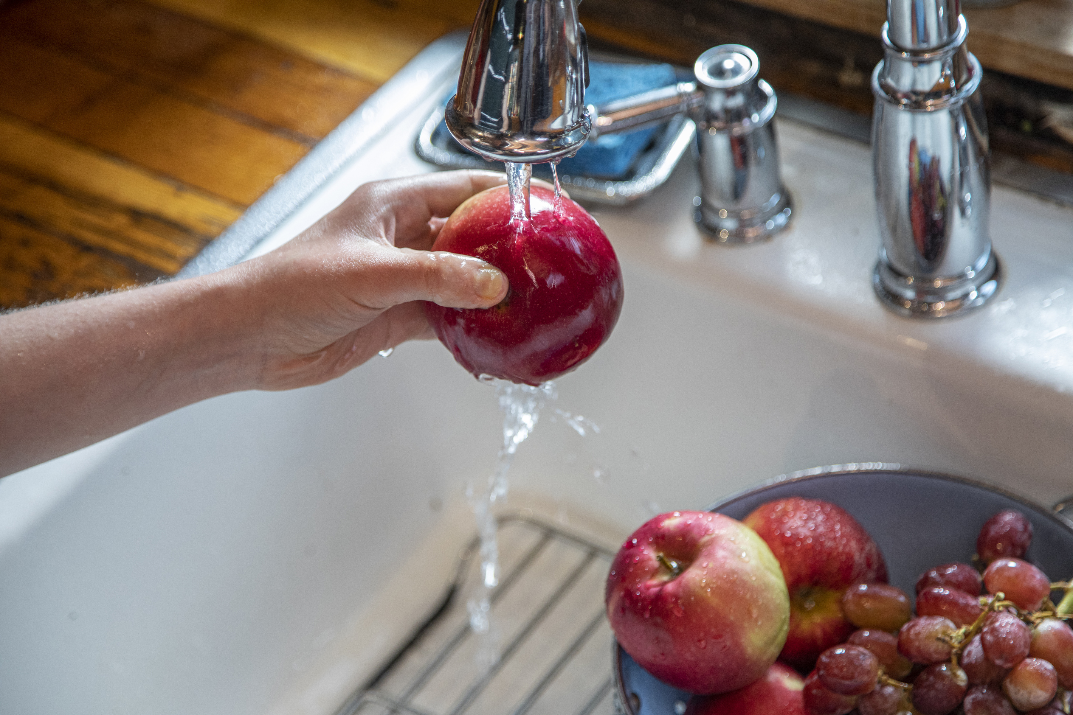 FILE -- Washing fruit in New York, May 21, 2020. To minimize the risk of food poisoning, you really do need to wash produce before eating it, though no special produce washes are required. (Tony Cenicola/The New York Times)