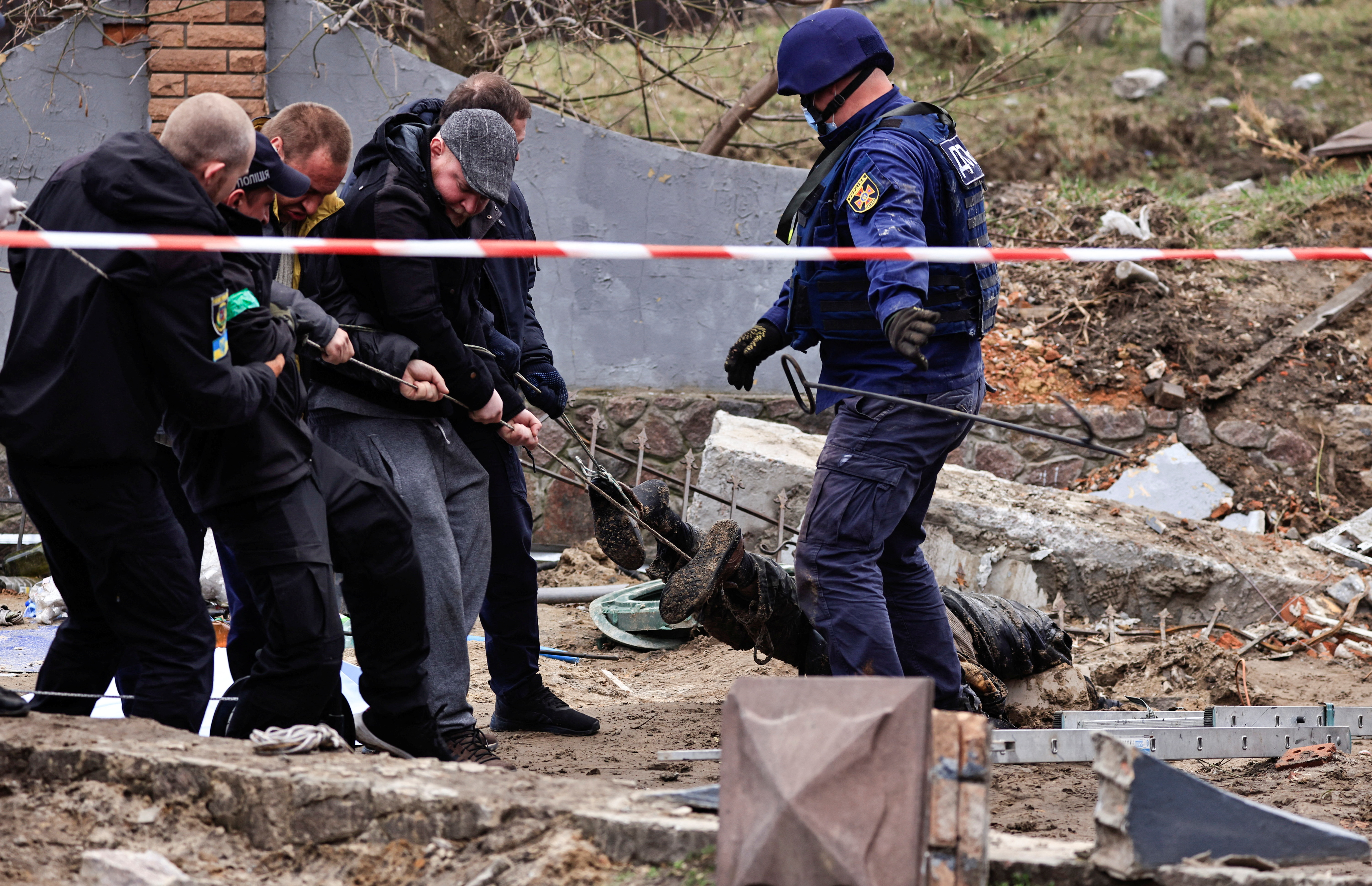 Rescatistas remueven entre los escombros el cuerpo de un civil en Buzova, en la región de Kiev (Reuters)