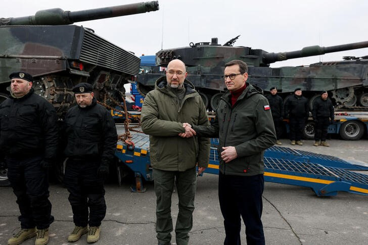 El primer ministro ucraniano, Denys Shmyhal (izq), y su homólogo polaco, Mateusz Morawiecki, saludándose junto a los primeros tanques Leopard 2 entregados por Varsovia a Kiev. Servicio de Prensa del Gobierno de Ucrania/entrega vía Reuters