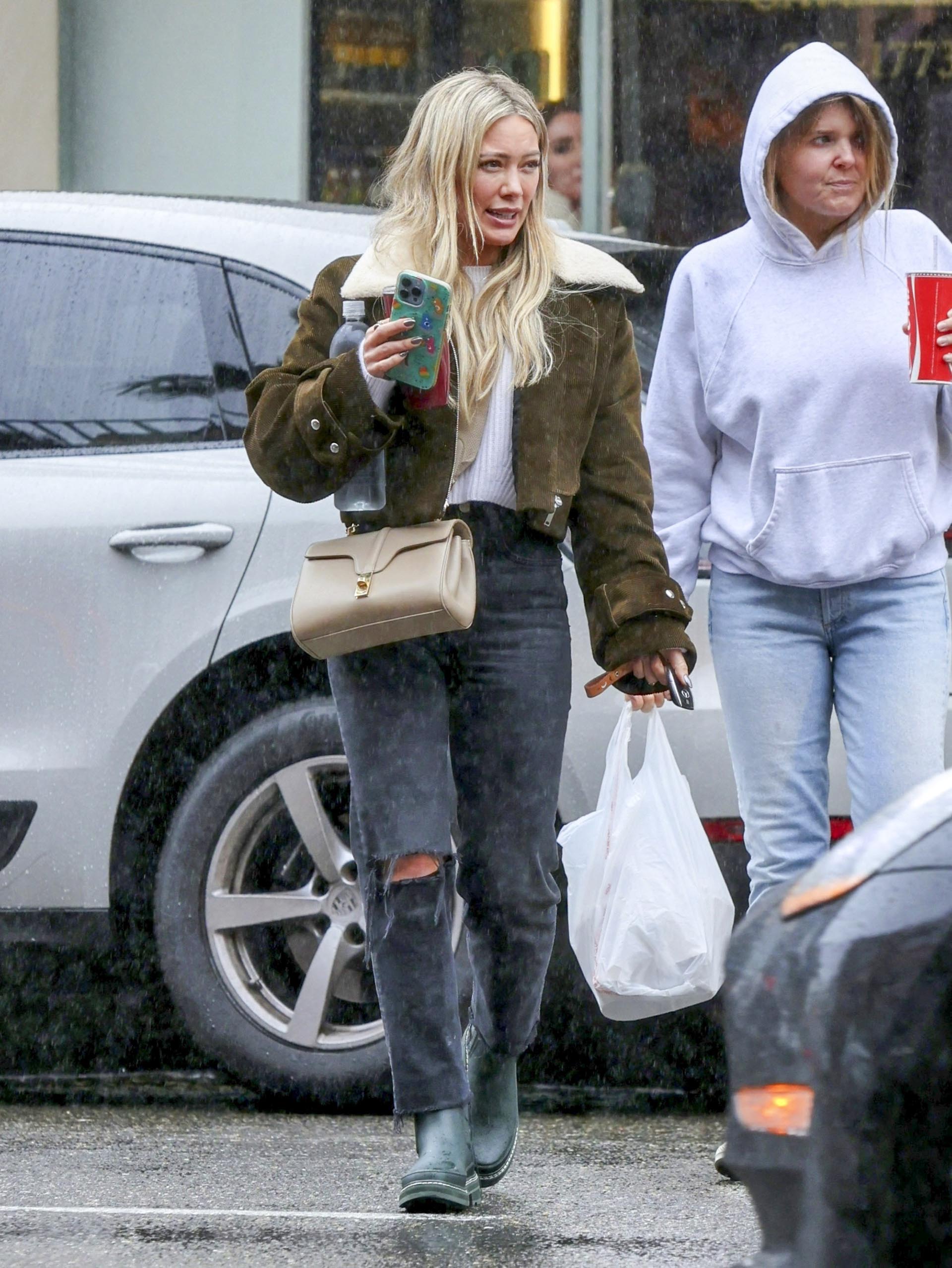 Hilary Duff fue fotografiada cuando salía de un restaurante de Los Ángeles en el que compró comida para llevar. La actriz vestía un jean roto a la altura de la rodilla, una remera blanca y una campera color musgo con detalles de piel sintética en el cuello