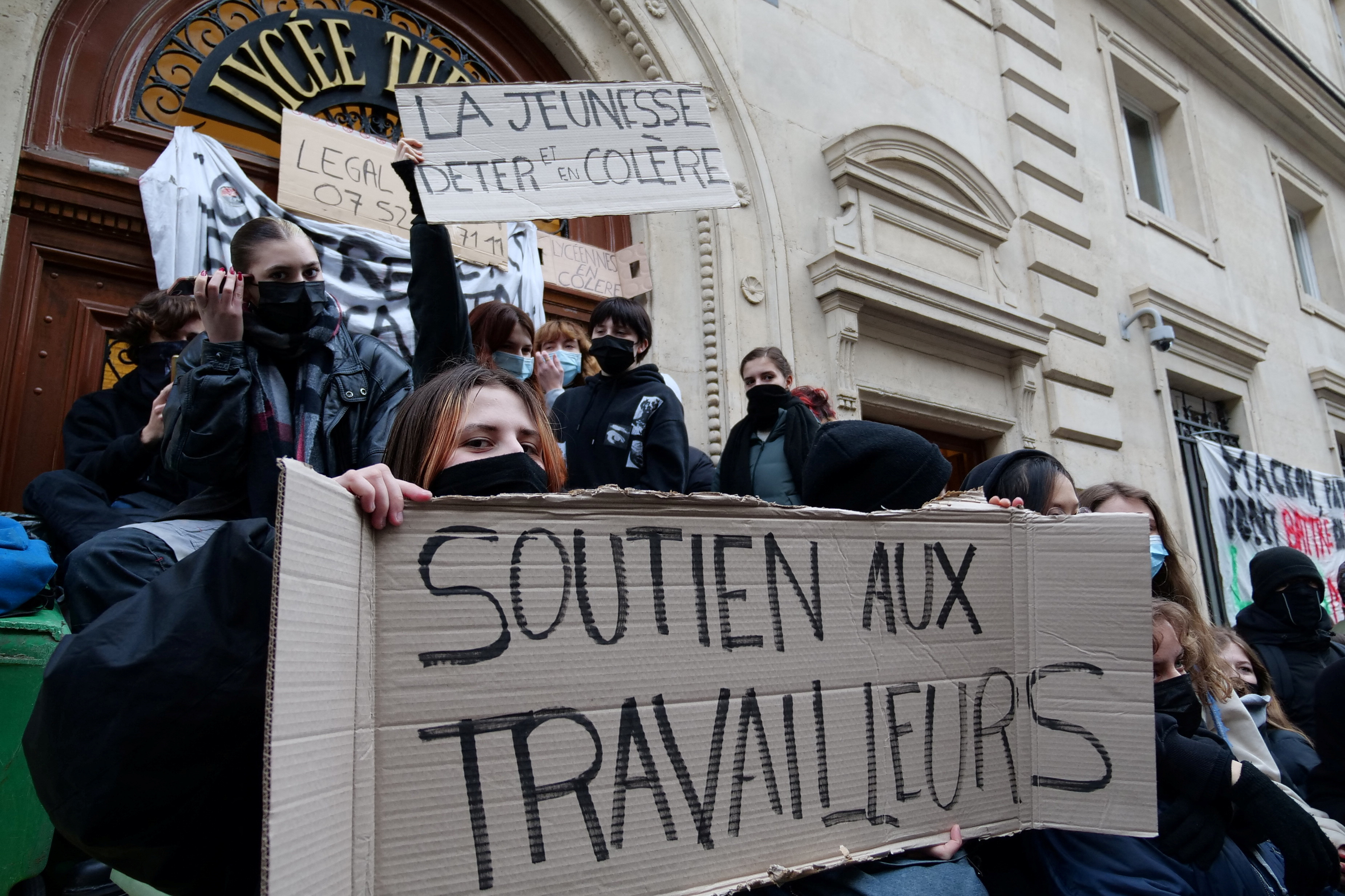 Estudiantes bloquean el ingreso a un liceo en París, con carteles de "Apoyo a los trabajadores" y "Juventud molesta" (Reuters)