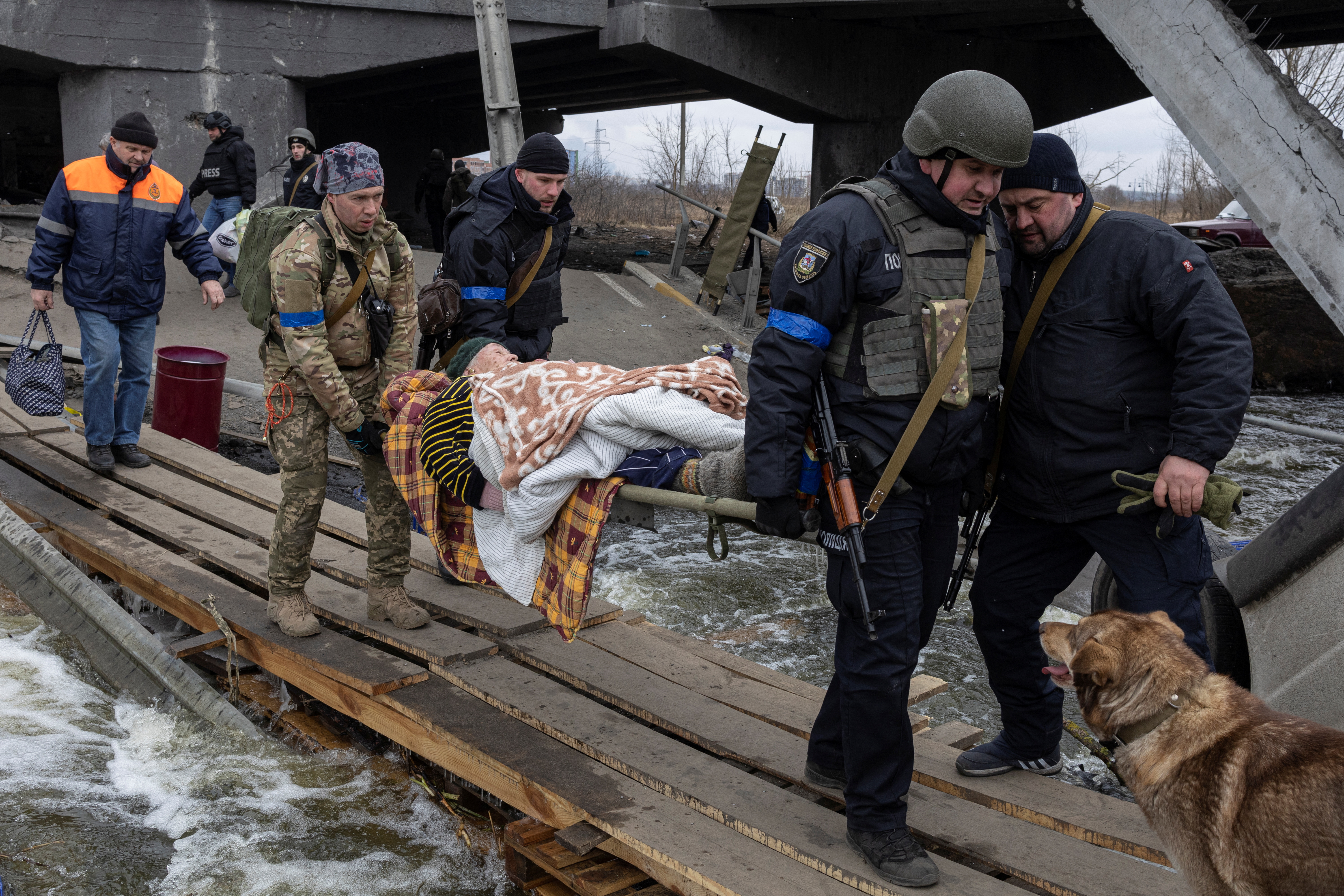 Militares ucranianos llevan a un anciano durante una evacuación en la ciudad de Irpin, a las afueras de Kiev, Ucrania, el 13 de marzo de 2022 (REUTERS/Marko Djurica)