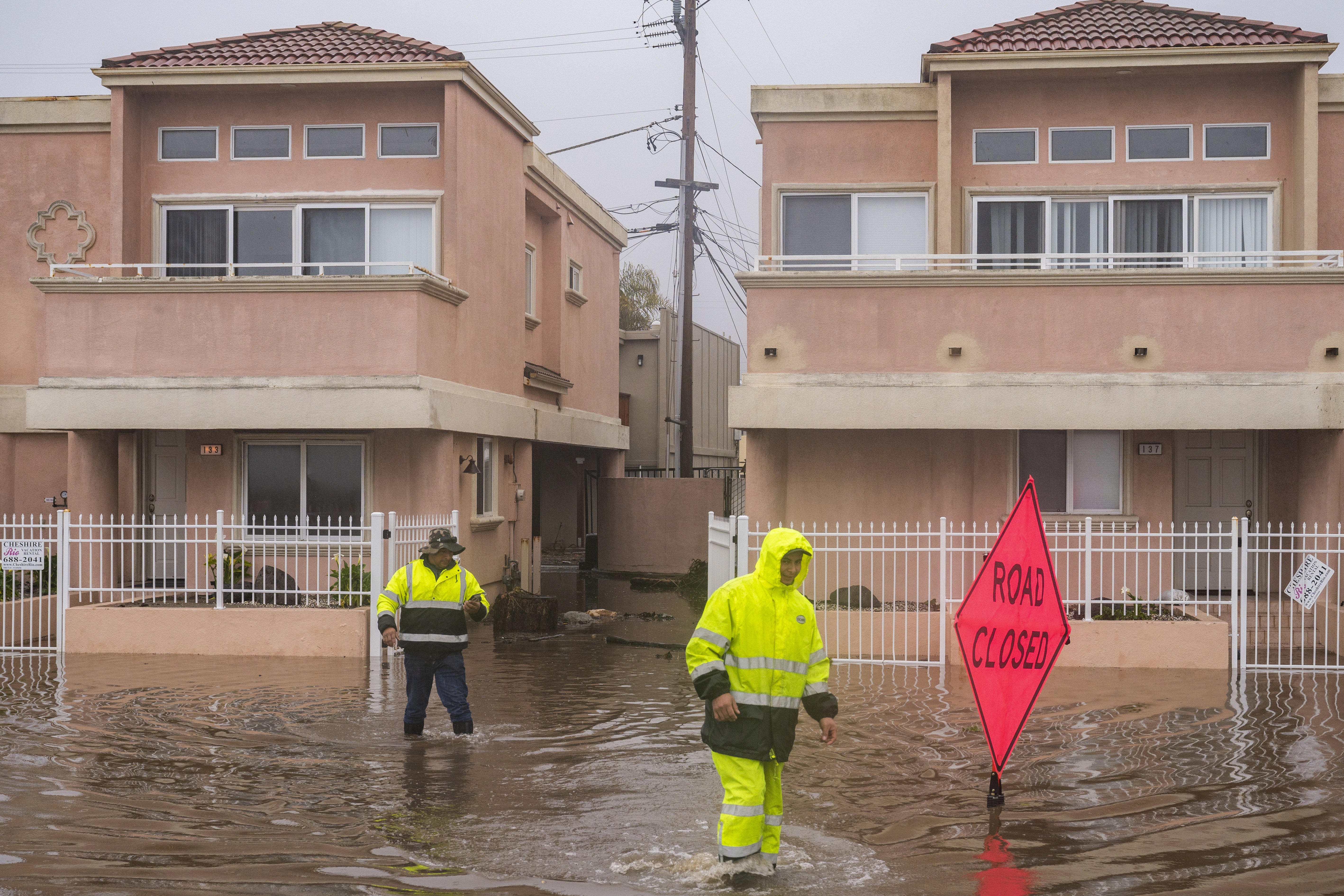 Un equipo de limpieza camina a través de las inundaciones en el vecindario Rio Del Mar de Aptos, California. (Foto AP/Nic Coury) 
