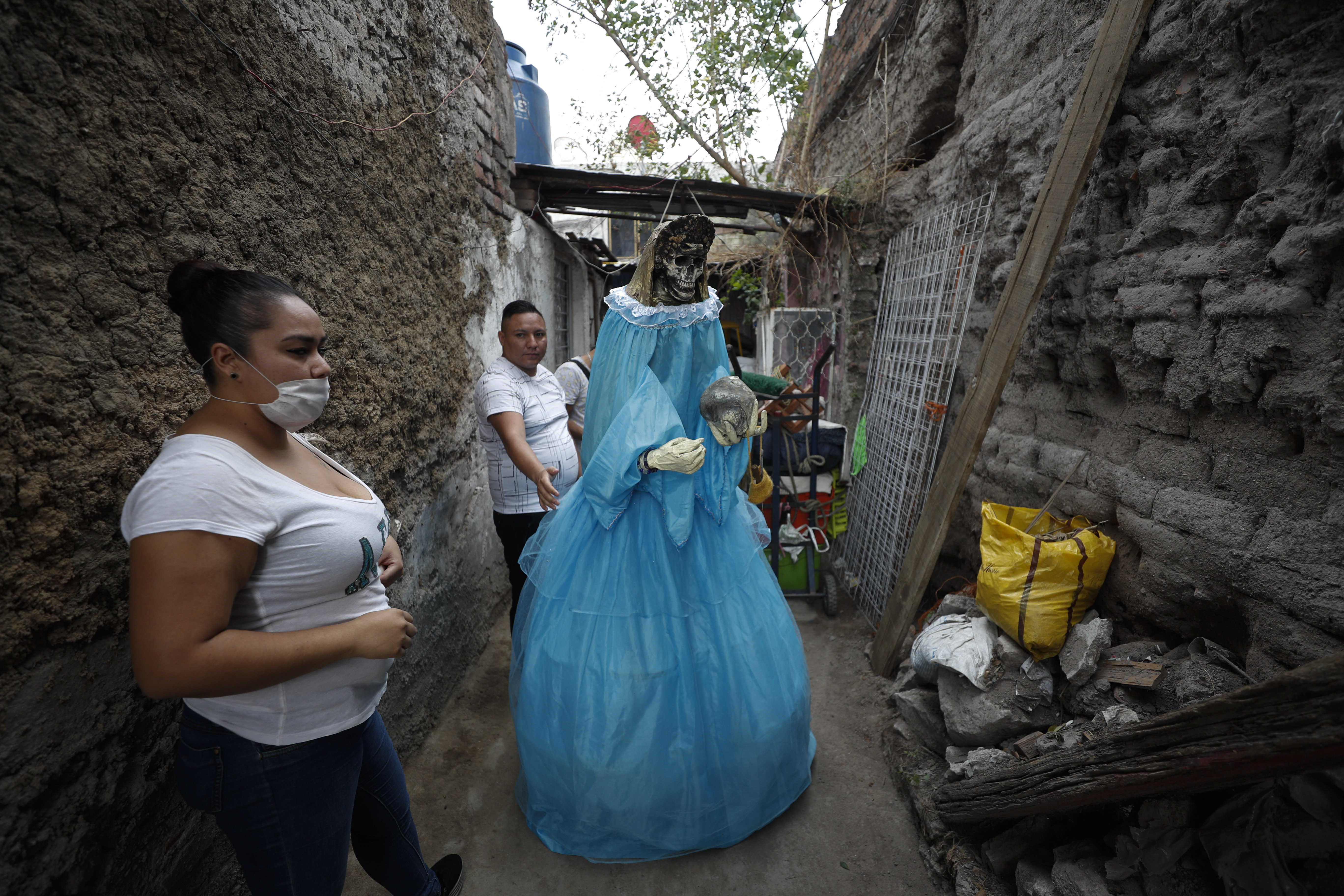 Los vecinos ayudan a devolver una figura gigante de la Santa Muerte a una casa después de que se exhibiera en la calle para celebrar el día del festival mensual del santo. (Foto: AP / Rebecca Blackwell)