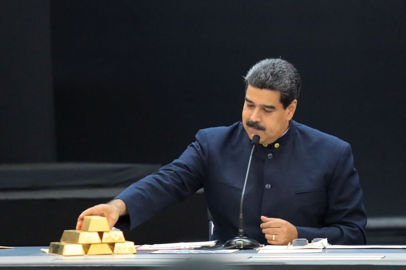 Foto de archivo del presidente de Venezuela, Nicolas Maduro, tocando una pila de lingotes de oro durante una rueda de prensaa en el Palacio de Miraflores en Caracas (REUTERS/Marco Bello)