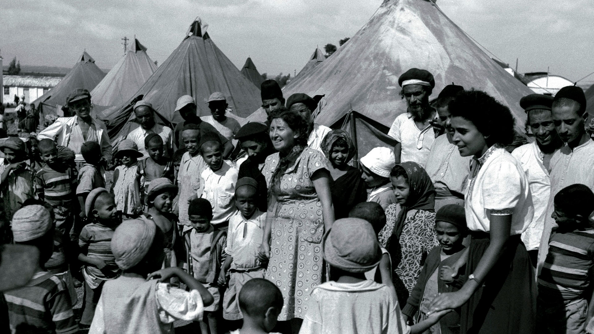 Inmigrantes judíos de Yemen en un campamento de tiendas de campaña en 1949 mientras son visitados por enfermeras israelíes (REUTERS)