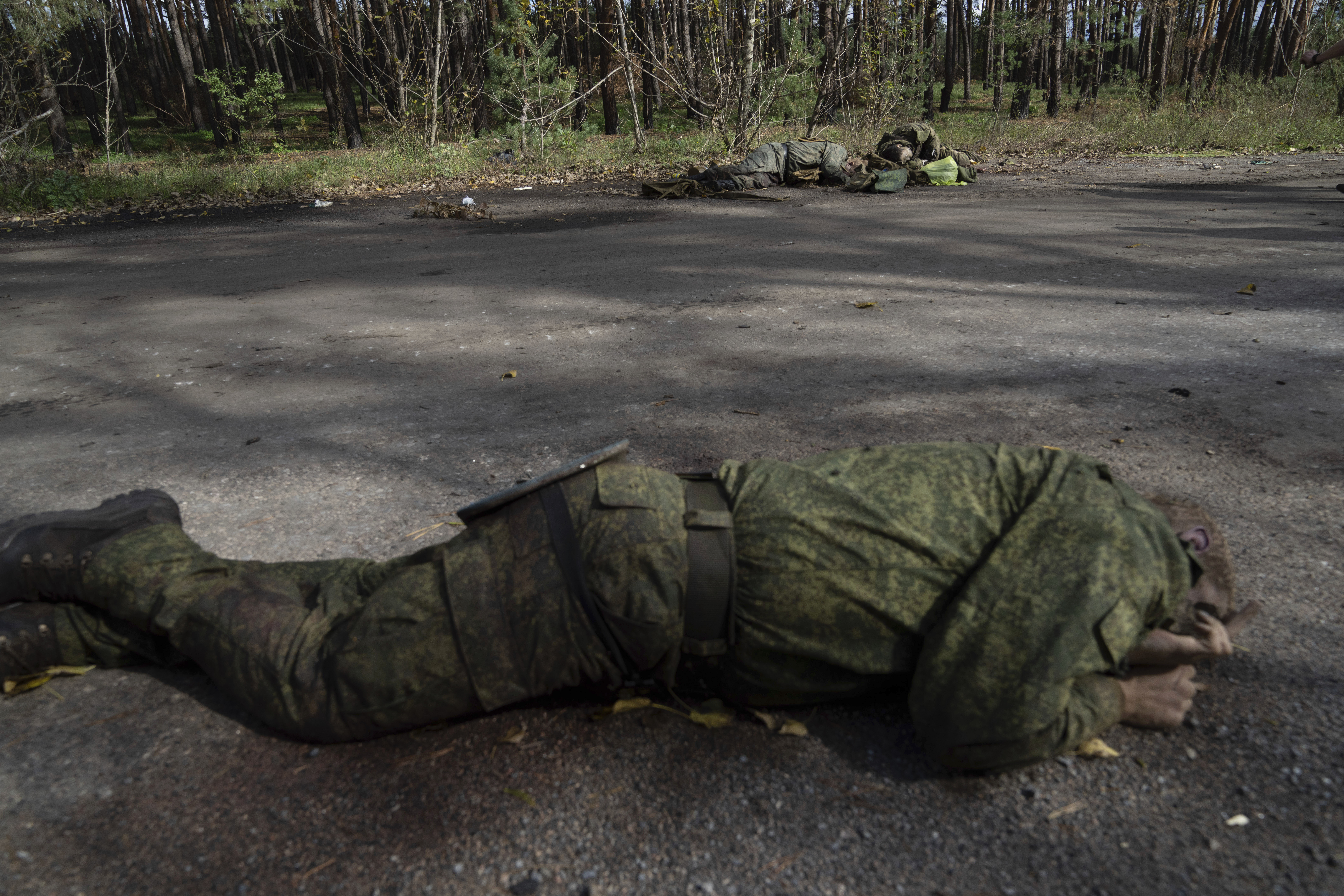 Cuerpos de militares rusos muertos se ven en el suelo en la ciudad de Lyman, recién recuperada por fuerzas ucranianas, en Lyman, Ucrania, el lunes 3 de octubre de 2022. (AP foto/Evgeniy Maloletka)