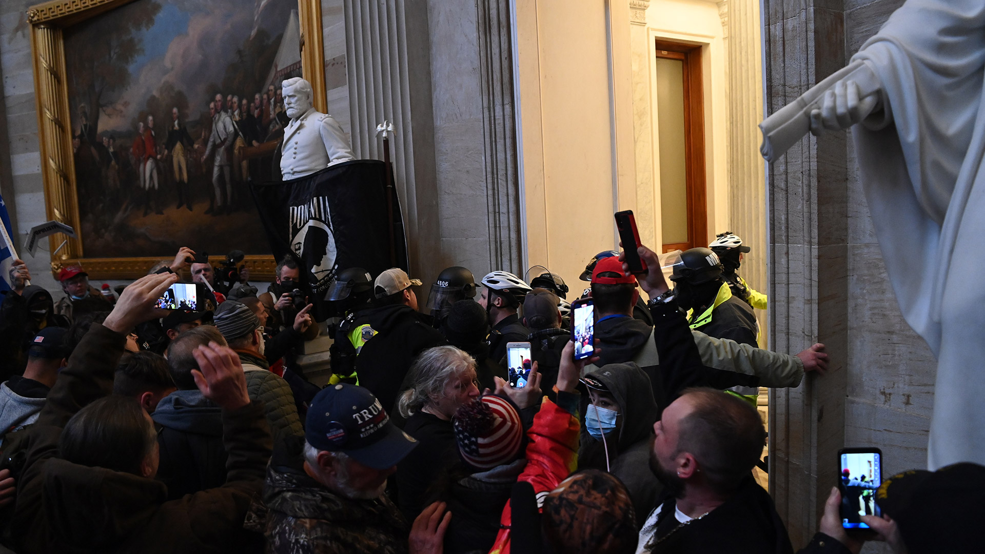 Partidarios de Trump intentan romper un cerco policial dentro del Capitolio. Foto: Saul LOEB / AFP
