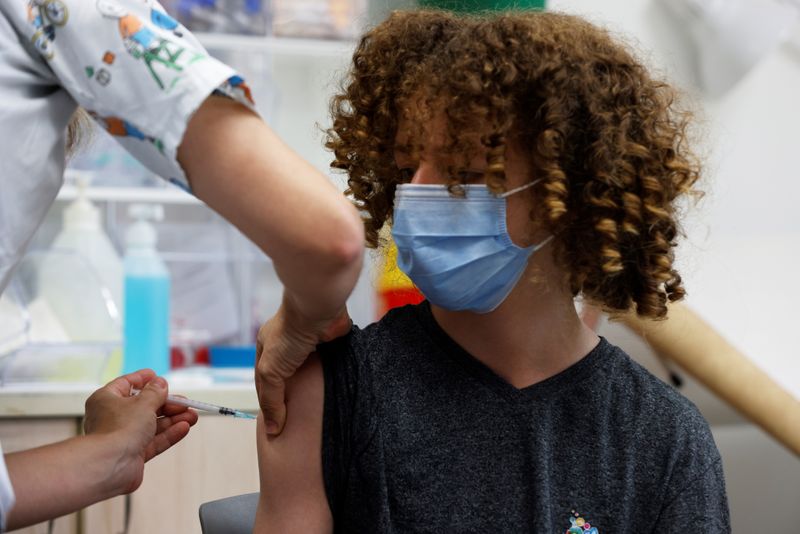 FOTO DE ARCHIVO: Un adolescente con mascarilla recibe una dosis de la vacuna contra la COVID-19 en un centro médico de Tel Aviv, Israel, el 21 de junio de 2021. REUTERS/Amir Cohen