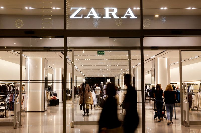 Some shoppers walk past a Zara clothing store, owned by the Spanish group Inditex.  (Reuters)