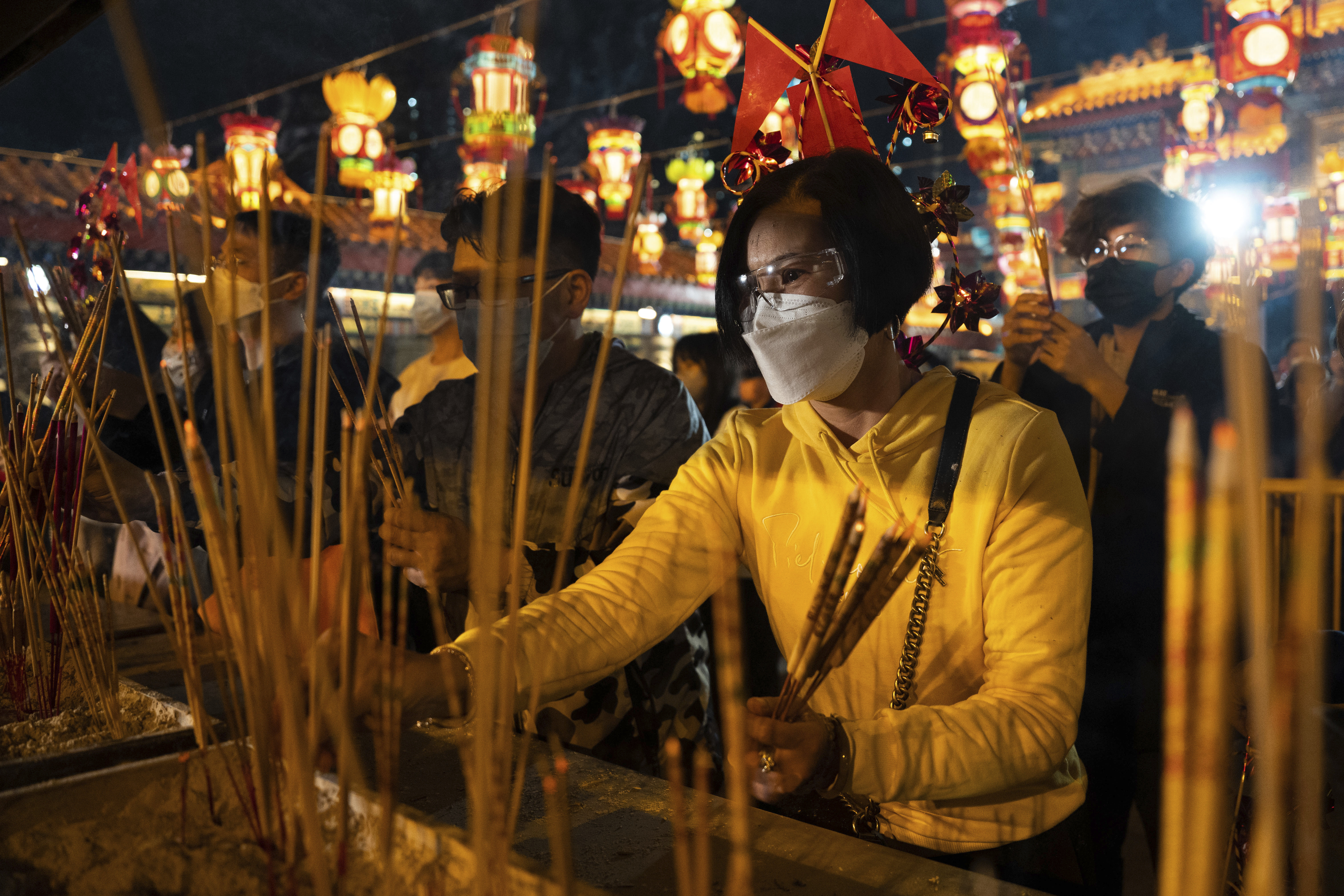 Worshipers wearing face masks light their first incense sticks of the year to pray at Wong Tai Sin Temple in Hong Kong on Saturday, January 21, 2023, to celebrate the Lunar New Year and the start of the Year of the Rabbit.  (AP Photo/Bertha Wang)