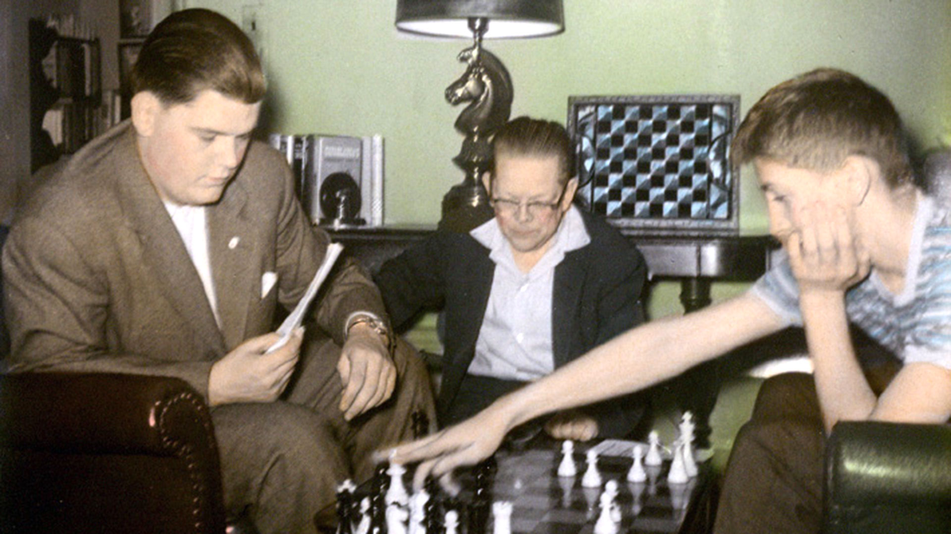Jack Collins estudia una partida con Bill Lombardy y Bobby Fischer. Collins, un maestro de ajedrez que como jugador llegó a ser uno de los cincuenta mejores del país, también tenía un buen pasar económico. Se convirtió en mentor de Bobby, quien quedó extasiado por la biblioteca ajedrecística de su nueva guía