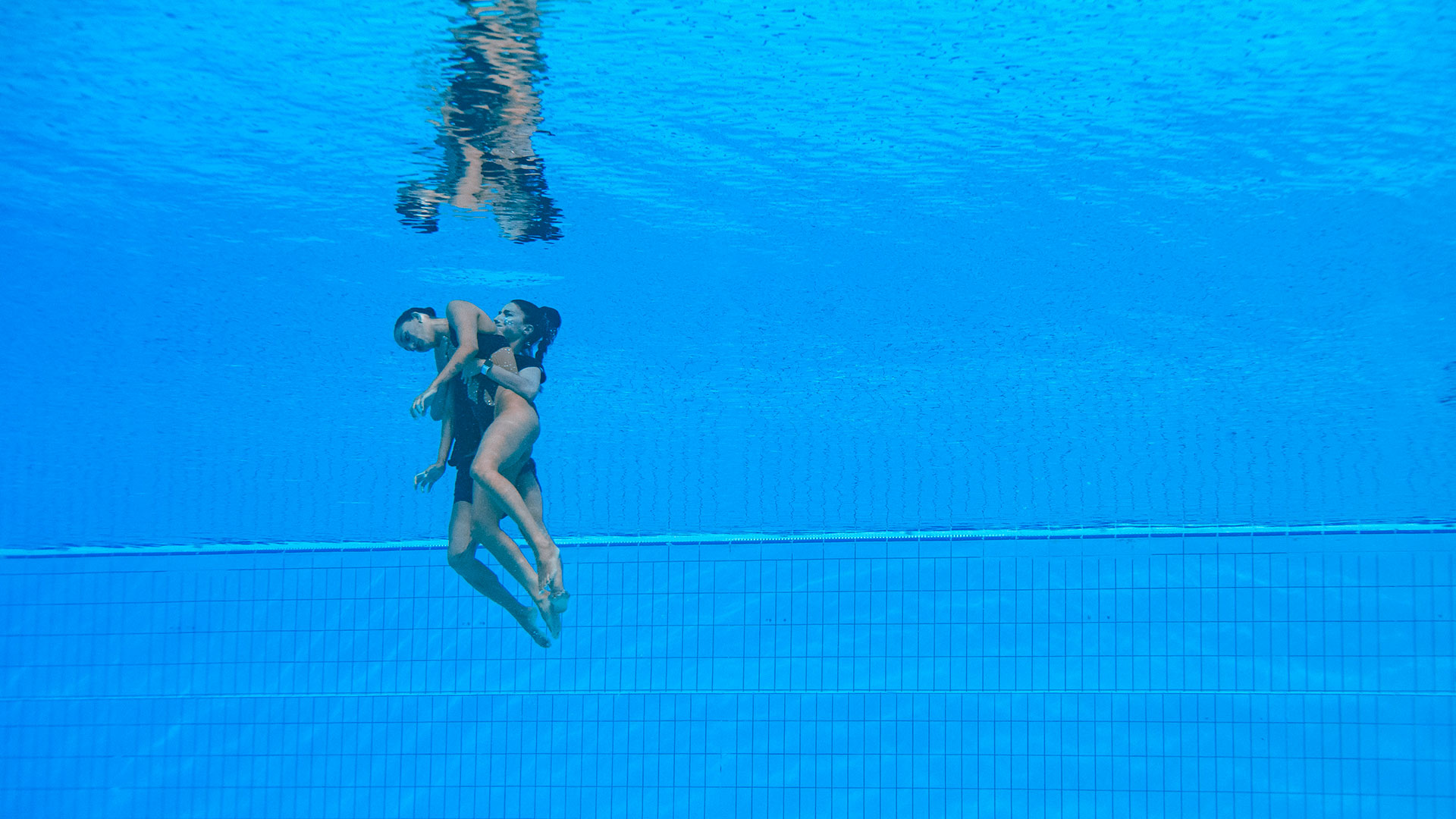 La entrenadora se tiró a la pileta para rescatar a la nadadora de su equipo (AFP)
