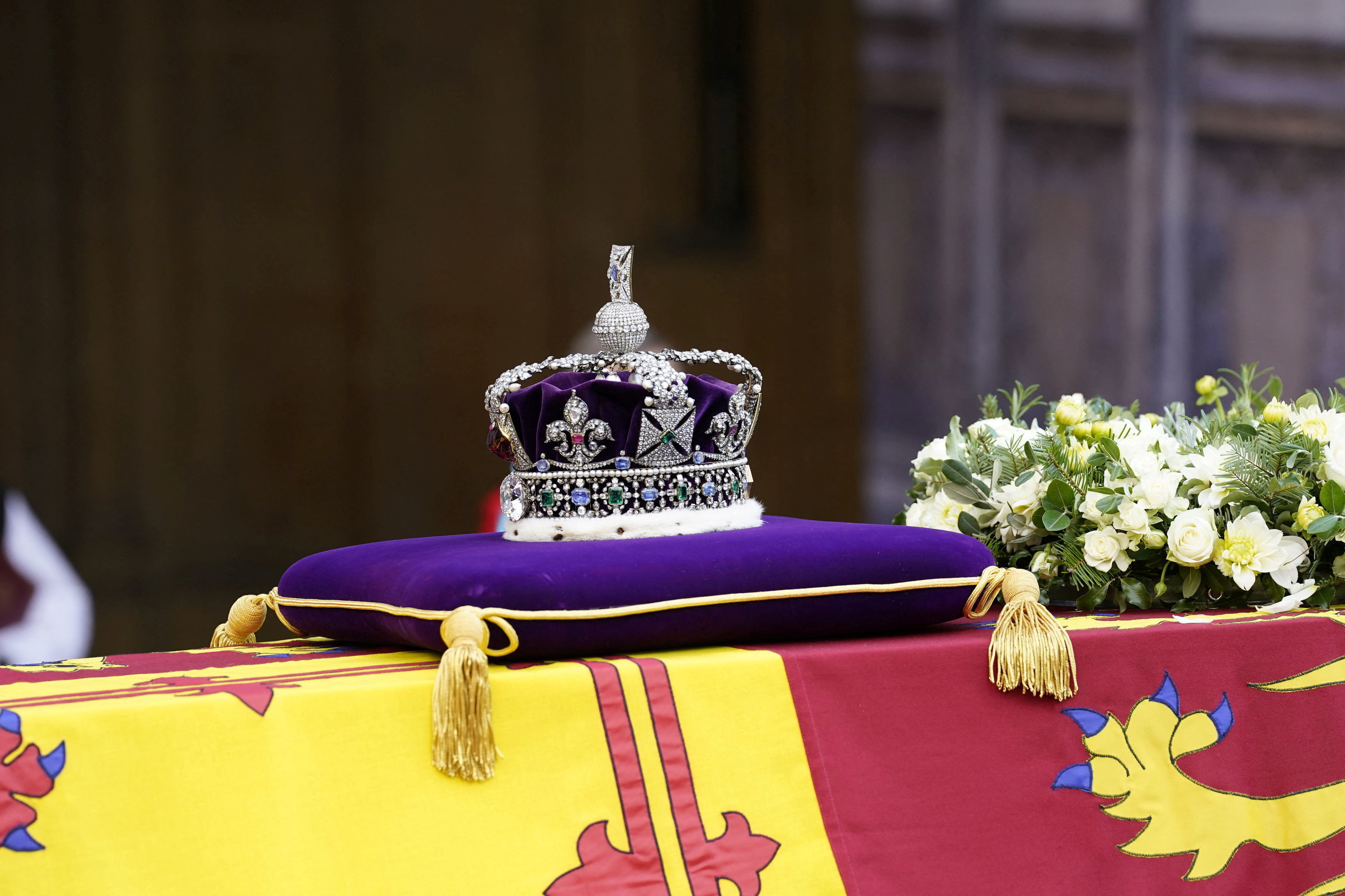 The coffin of queen elizabeth ii is draped in a royal banner, with the crown of the royal state placed on top