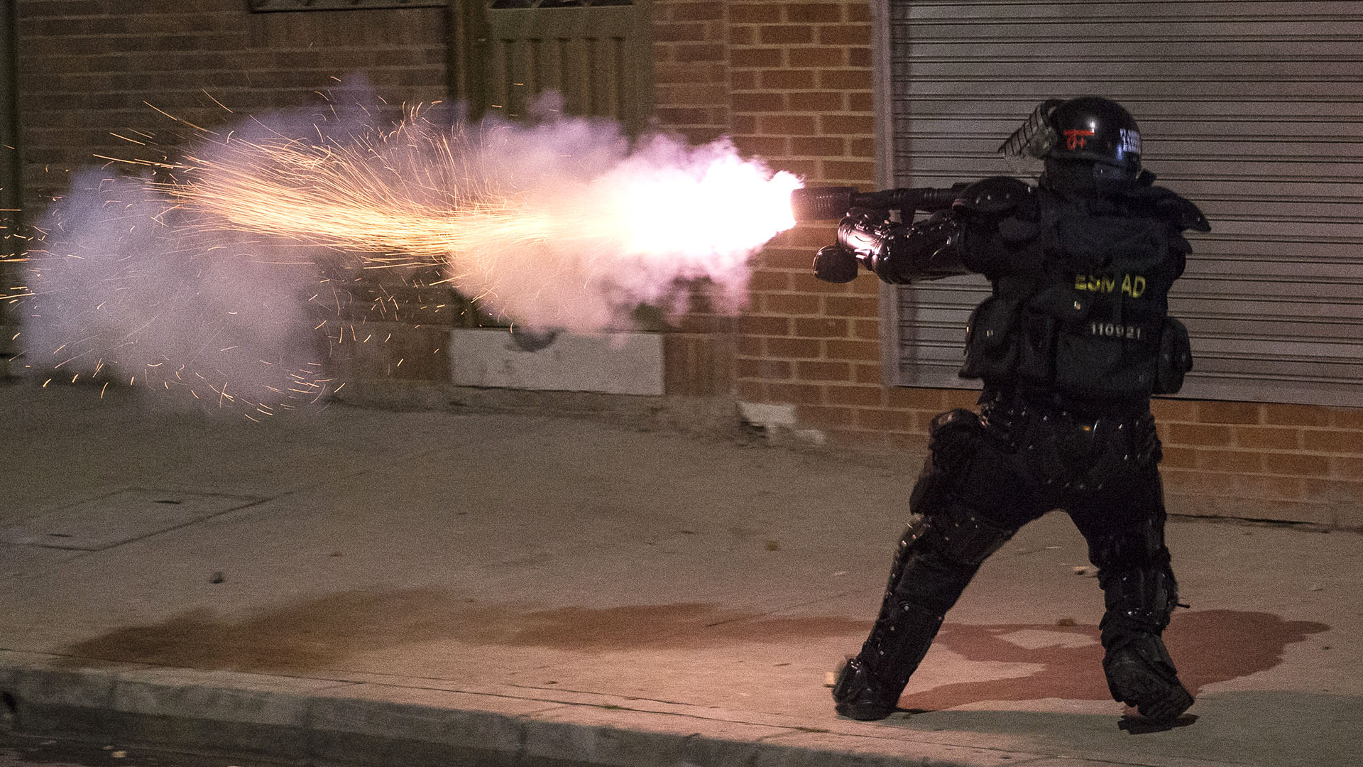 A police officer fires tear gas against demonstrators protestng the death of a man after he was detained by police in Bogota, Wednesday, Sept. 9, 2020. Javier Humberto Ordonez, 46, died in hospital after receiving repeated electric shocks with a stun gun from officers who detained him for violating social distancing rules to curb the spread of the coronavirus. (AP Photo/Ivan Valencia)