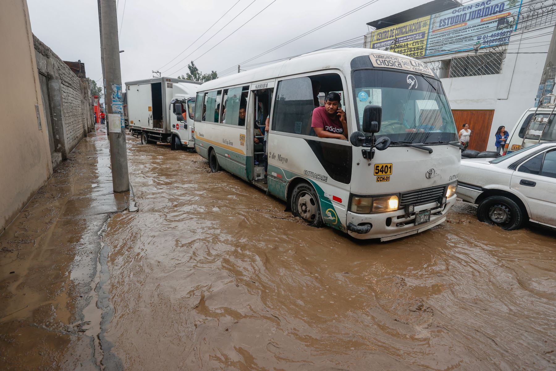 Vehículos de transporte intentan pasar por aniego de agua producto a las lluvias.