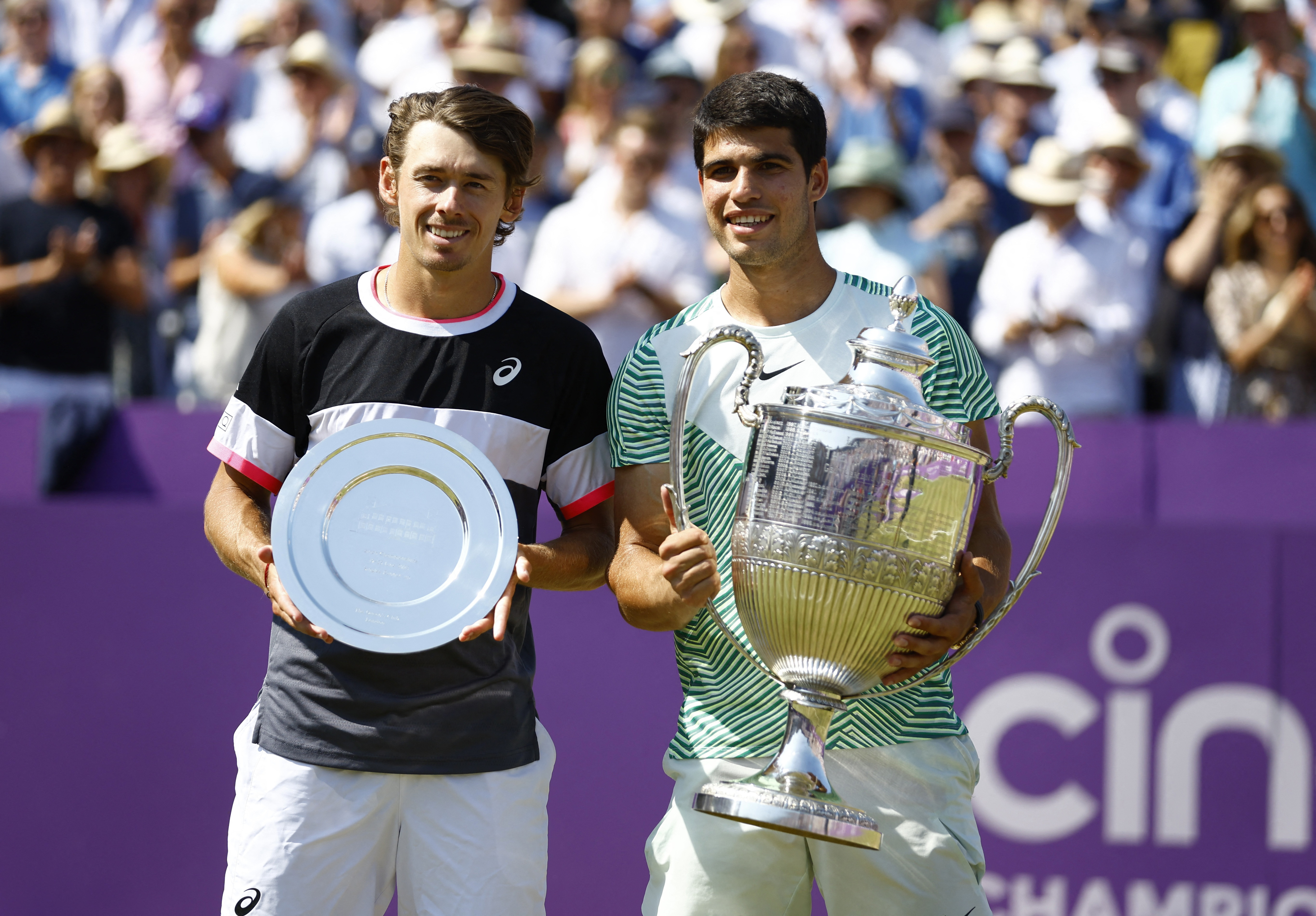 Alcaraz sostiene su trofeo de campeón y Álex de Miñaur se mostró conforme con su semana en Queen's (Foto: Reuters)