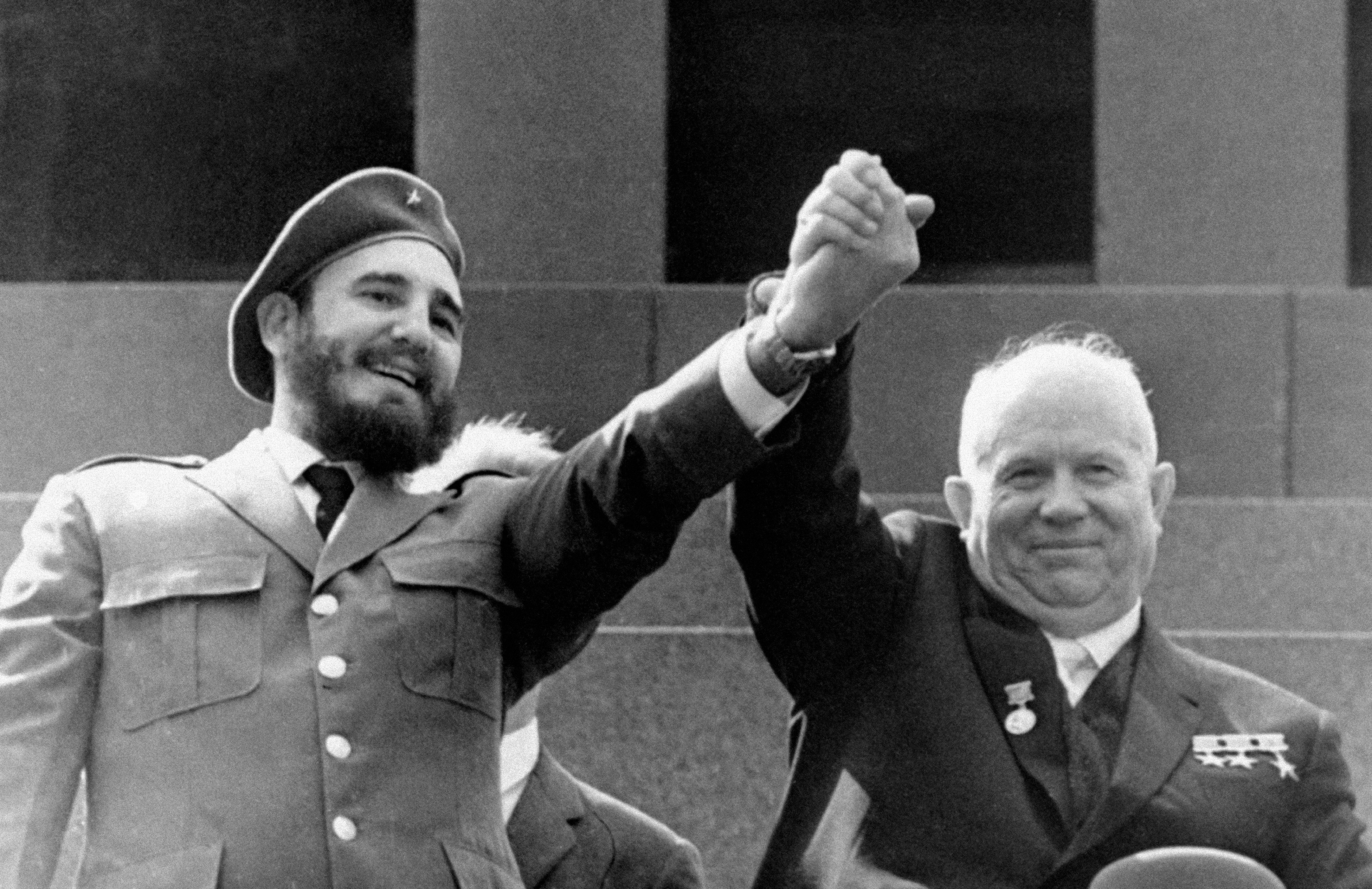 ARCHIVO - El líder cubano Fidel Castro, a la izquierda, y Nikita Khrushchev, primer ministro soviético y primer secretario del Partido Comunista de la Unión Soviética se dan la mano en el mausoleo de Lenin en la Plaza Roja de Moscú, el 1 de mayo de 1963.