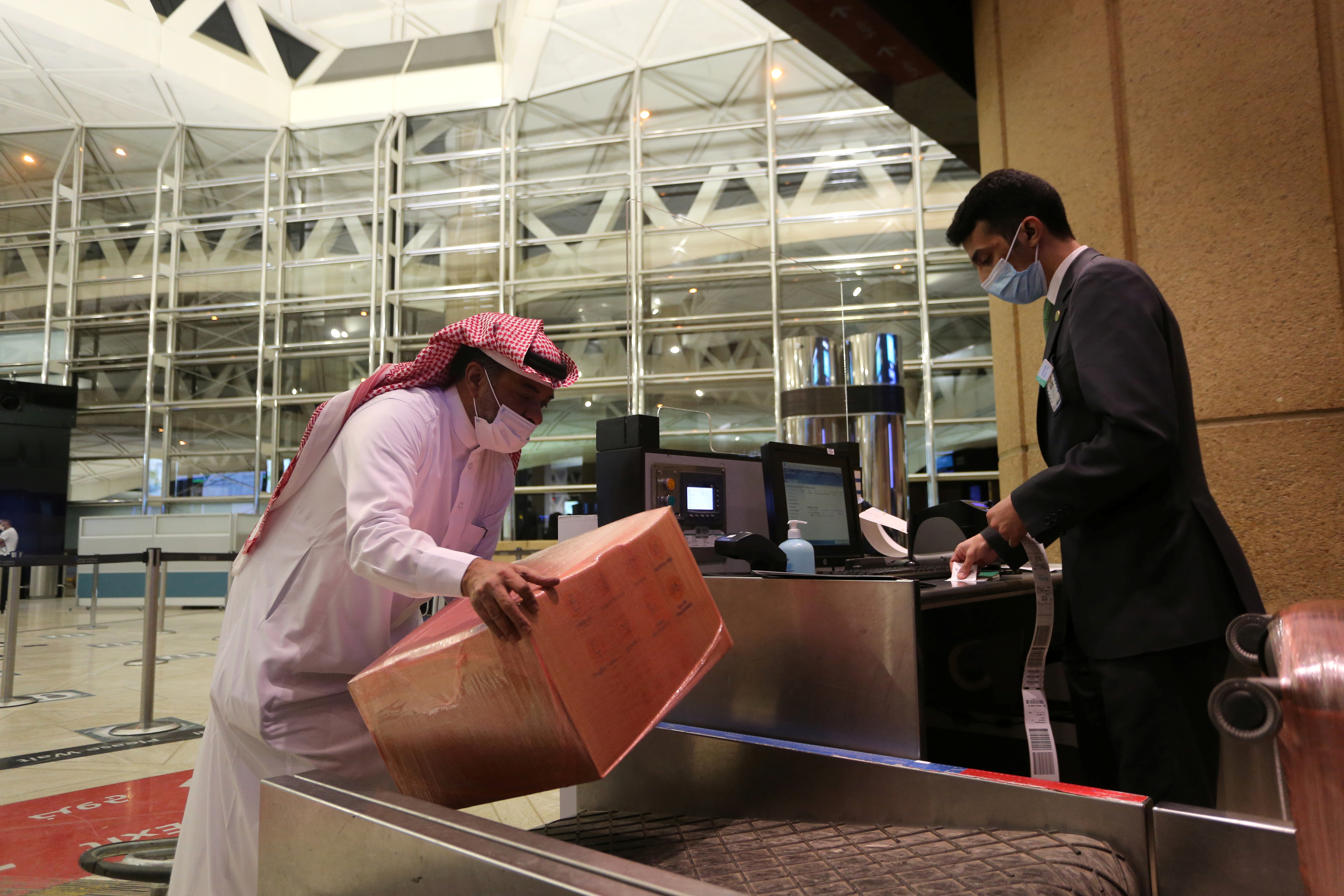 Un hombre saudí con una máscara facial registra su equipaje en el Aeropuerto Internacional Rey Khalid, luego de que las autoridades sauditas levantaran la prohibición de viajar a sus ciudadanos después de catorce meses debido a las restricciones de la enfermedad por coronavirus (COVID-19), en Riad, Arabia Saudita.
REUTERS/Ahmed Yosri