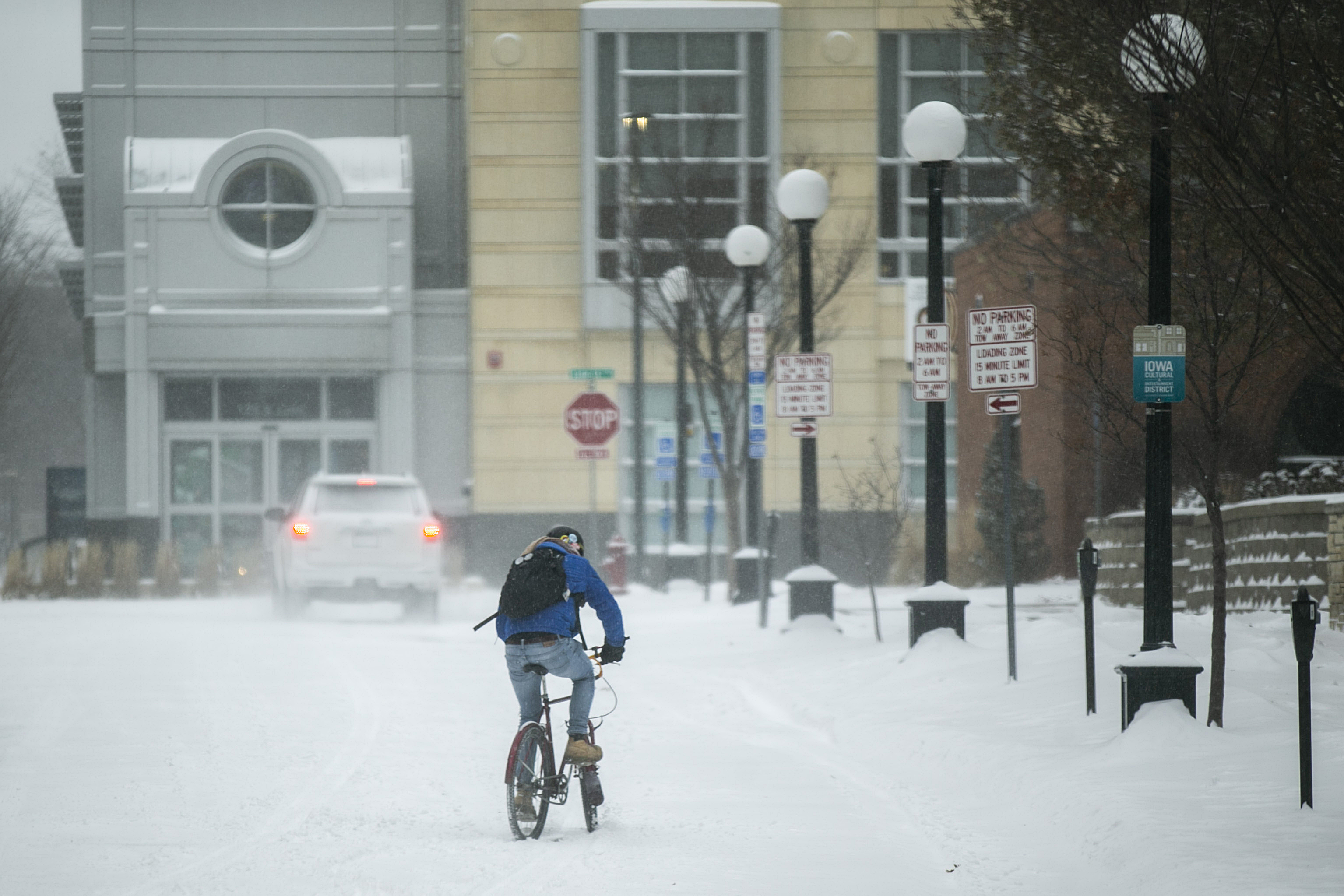 Un ciclista intenta maniobrar una carretera nevada durante una advertencia de tormenta de invierno en Iowa City, Iowa