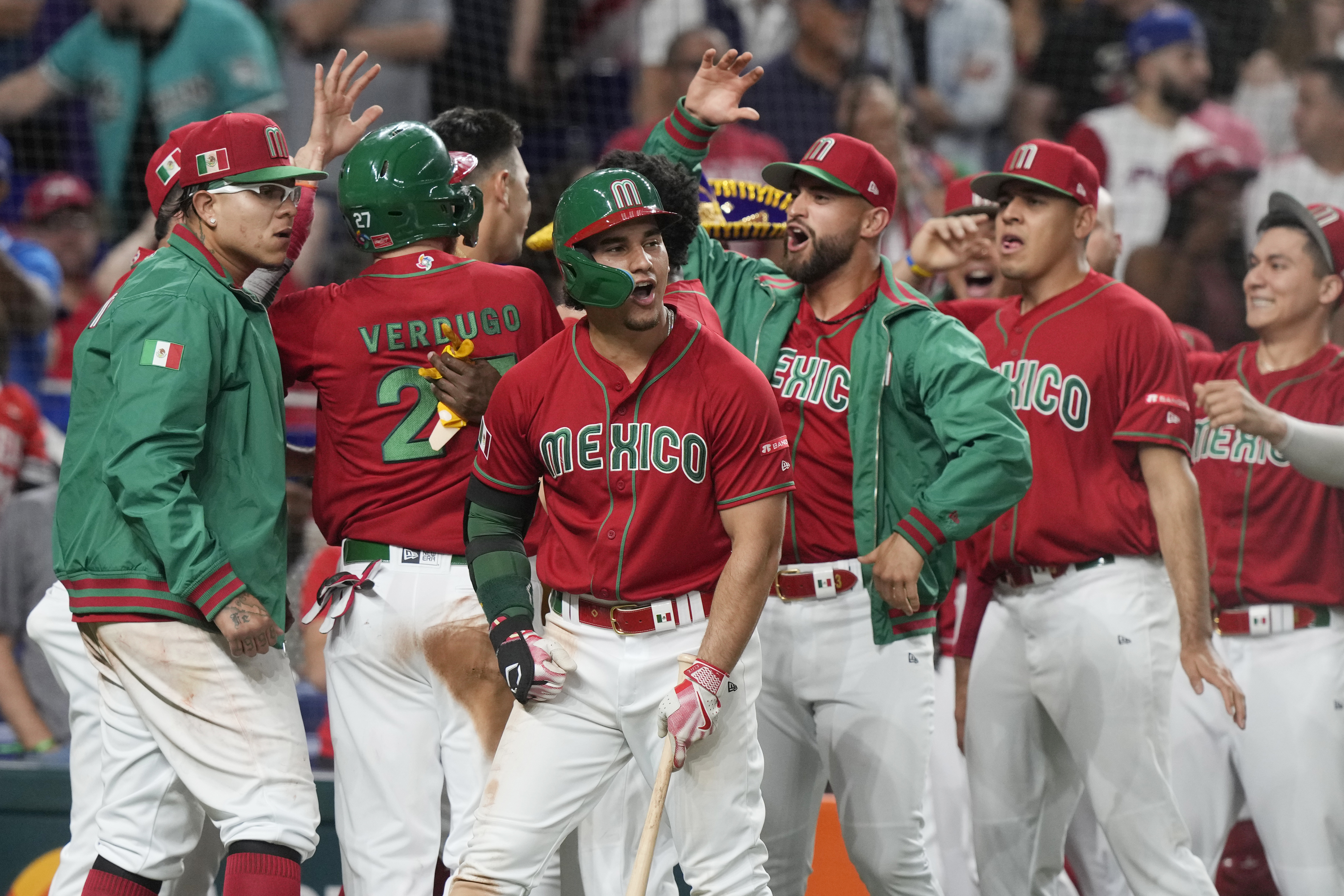The Mexican team celebrates with Alex Verdugo (27) after he scored a run in the seventh inning in the baseball game against Puerto Rico in the World Baseball Classic, Friday, March 17, 2023, in Miami.  (AP Photo/Marta Lavandier)