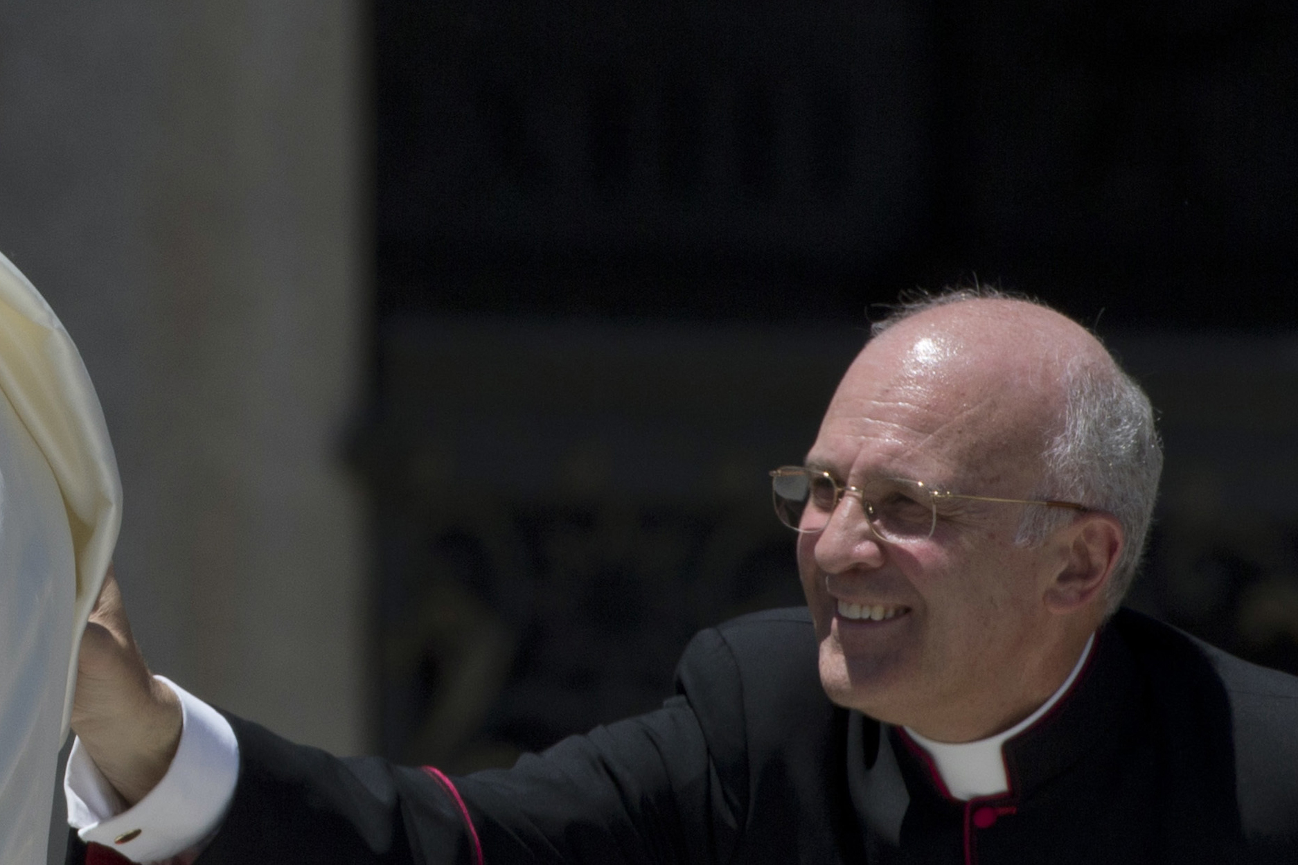 Monseñor Alfred Xuereb ajusta la capa del papa Francisco cuando sale de la plaza de San Pedro en el Vaticano, el 12 de junio de 2013. (Foto AP/Alessandra Tarantino, archivo)