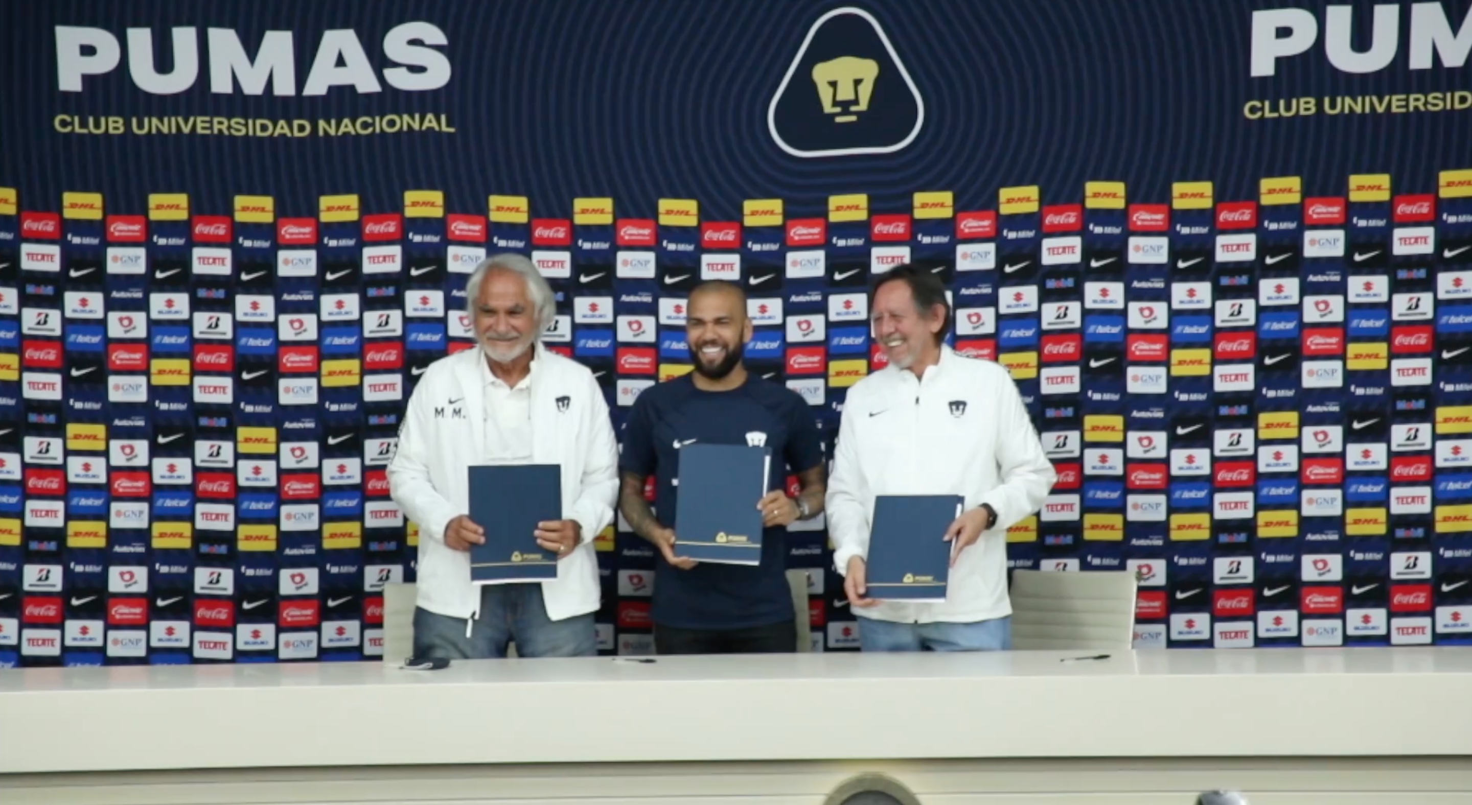 Dani Alves ya estampó sus primeras firmas como nuevo jugador de Pumas en compañía de Miguel Mejía Barón y Leopoldo Silva (Foto: Pumas MX)