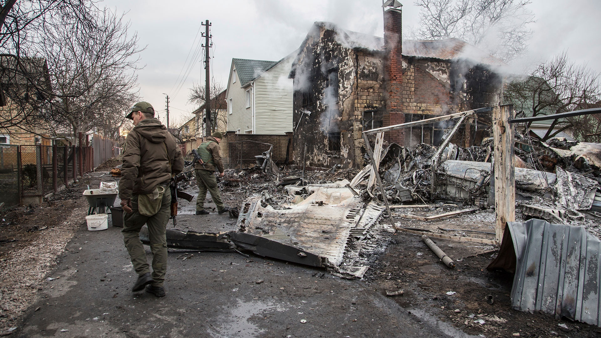 Un soldado ucraniano camina entre los restos de un avión derribado en Kiev, Ucrania (AP Foto/Oleksandr Ratushniak)