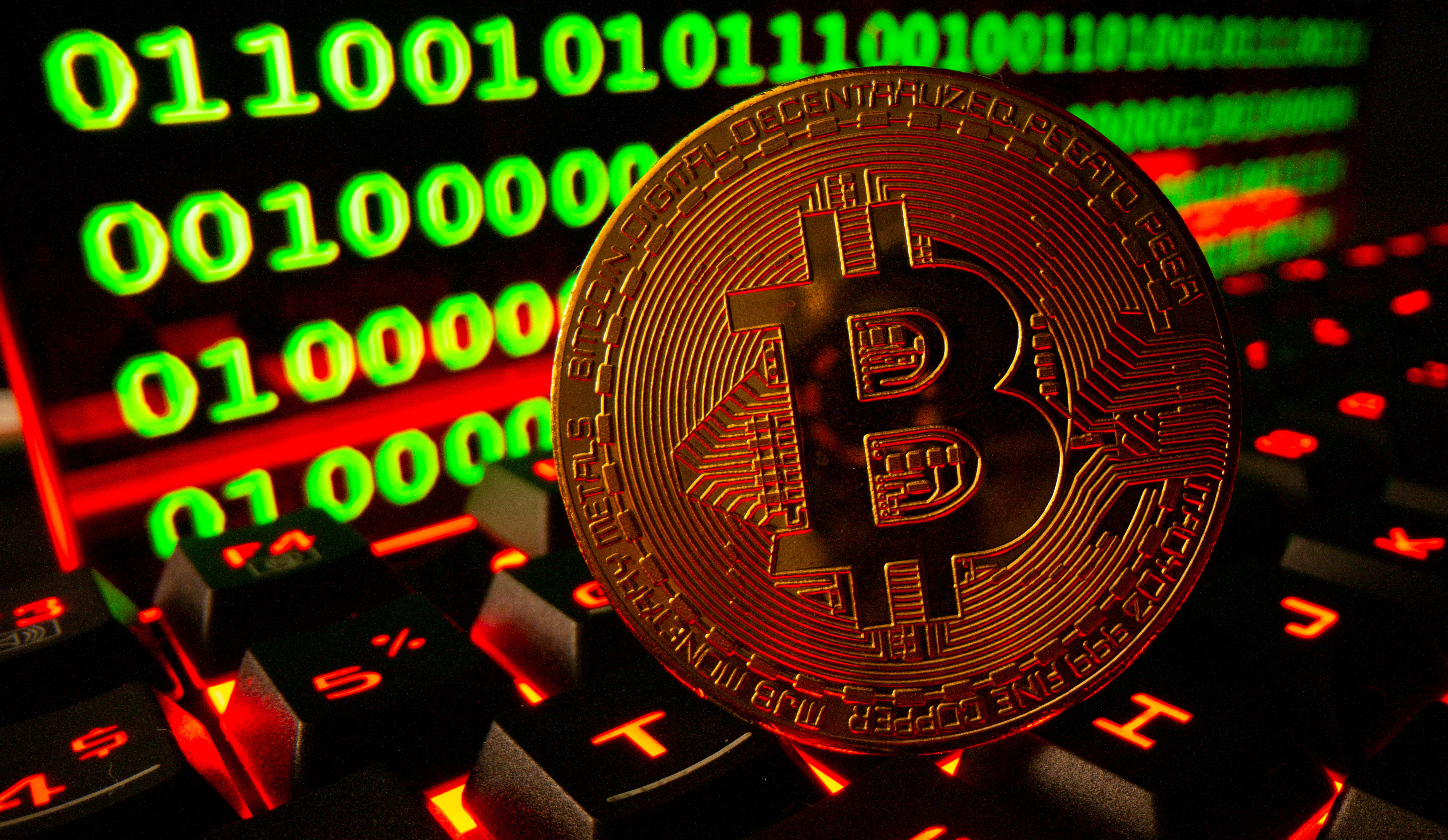 FILE PHOTO: Bitcoin cryptocurrency representation is pictured on a keyboard in front of binary code in this illustration taken September 24, 2021. REUTERS/Dado Ruvic/Illustration/File Photo
