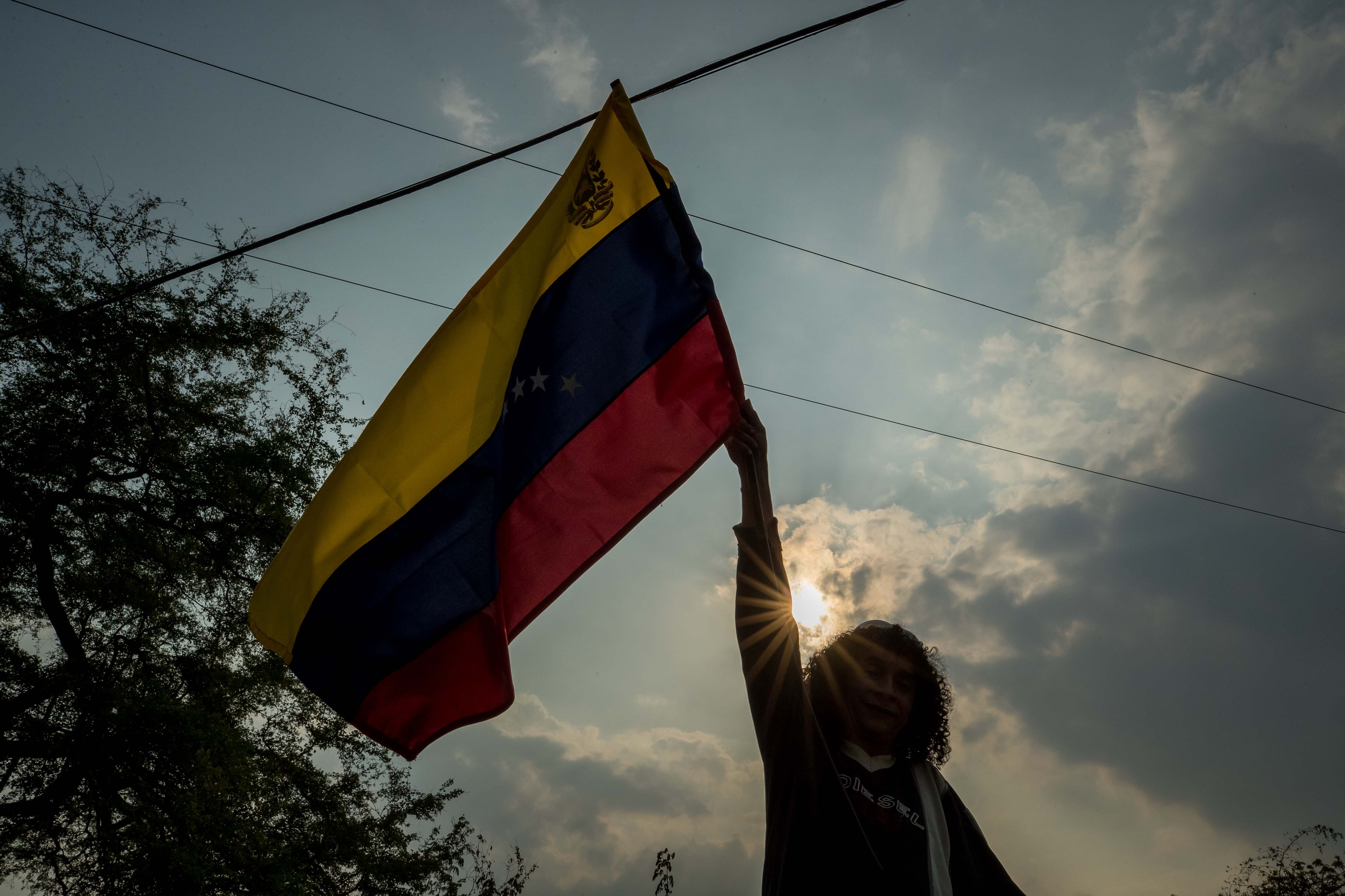 Una mujer mientras ondea una bandera de Venezuela, en Barinas (Venezuela). EFE/ Miguel Gutiérrez
