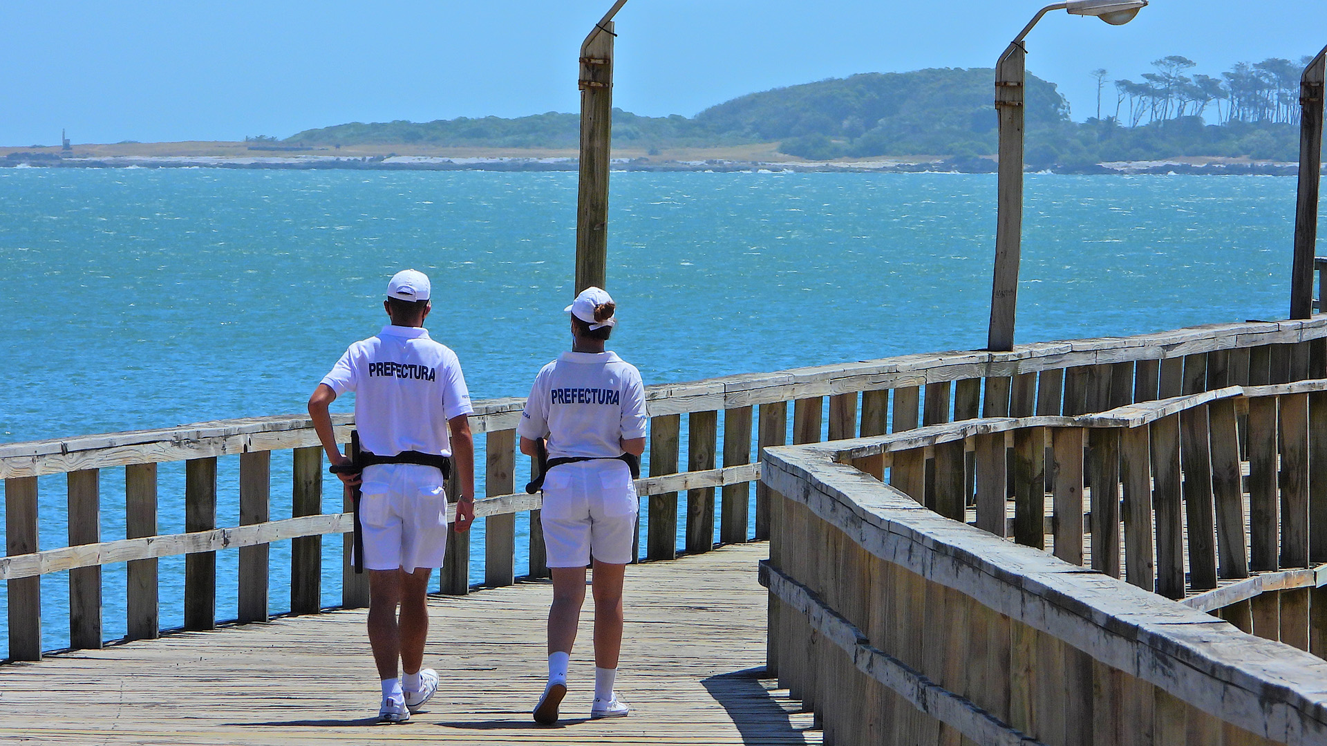 Dos prefectos caminan sobre un muelle de la Playa Mansa, en Punta del Este. (Marcelo Umpierrez)
