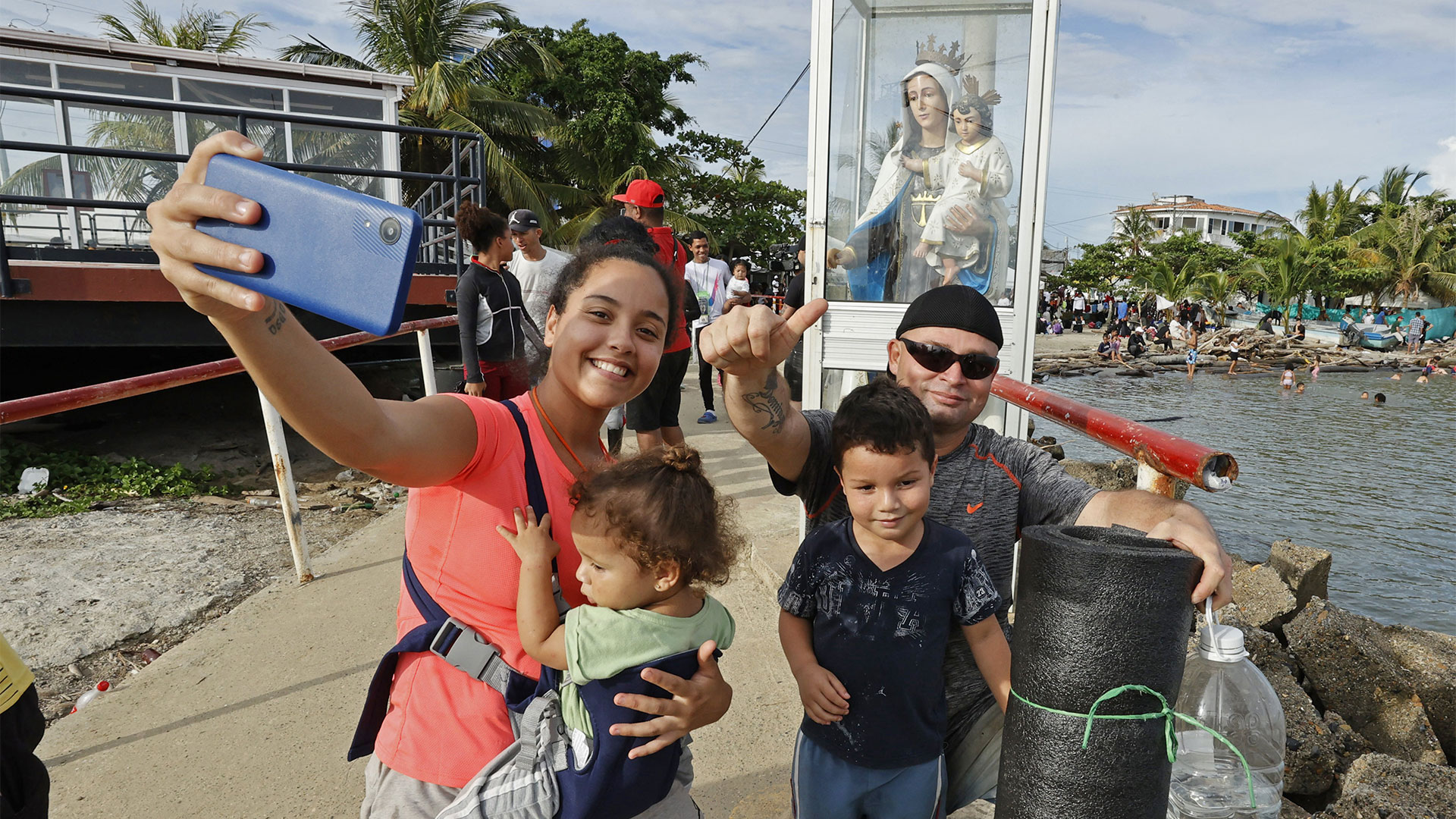 Migrantes venezolanos se toman una fotografía mientras se preparan para abordar una lancha hacia la frontera con Panamá (EFE/Mauricio Dueñas Castañeda)