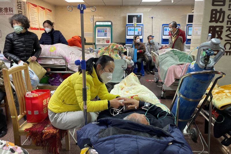 PHOTO DE DOSSIER: Des patients sont allongés sur des lits et des civières dans un couloir d'un service d'urgence d'un hôpital, au milieu de l'épidémie de la maladie à Shanghai (REUTERS / Personnel)