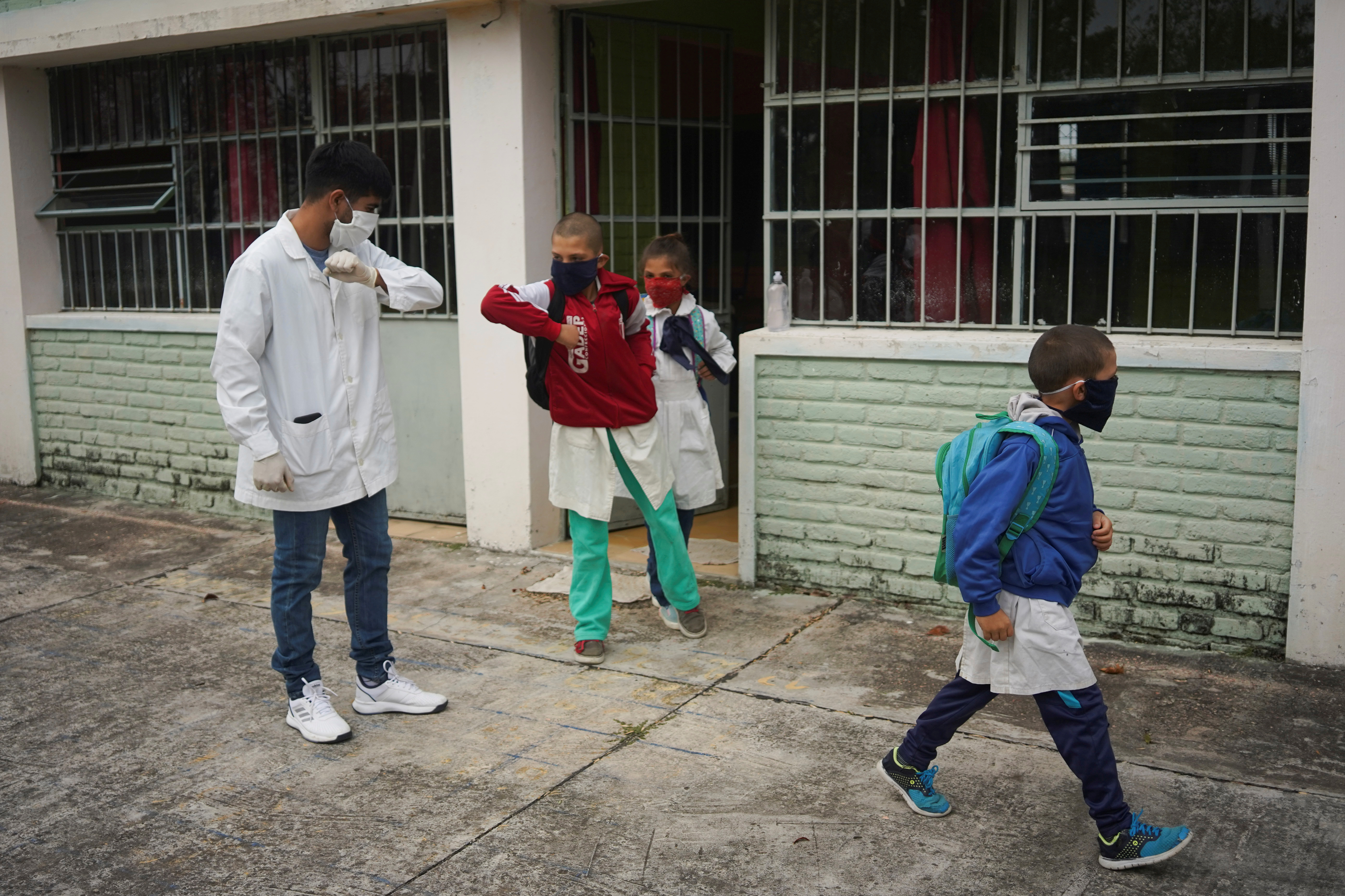 El maestro saluda a los estudiantes con el codo (REUTERS/Mariana Greif)